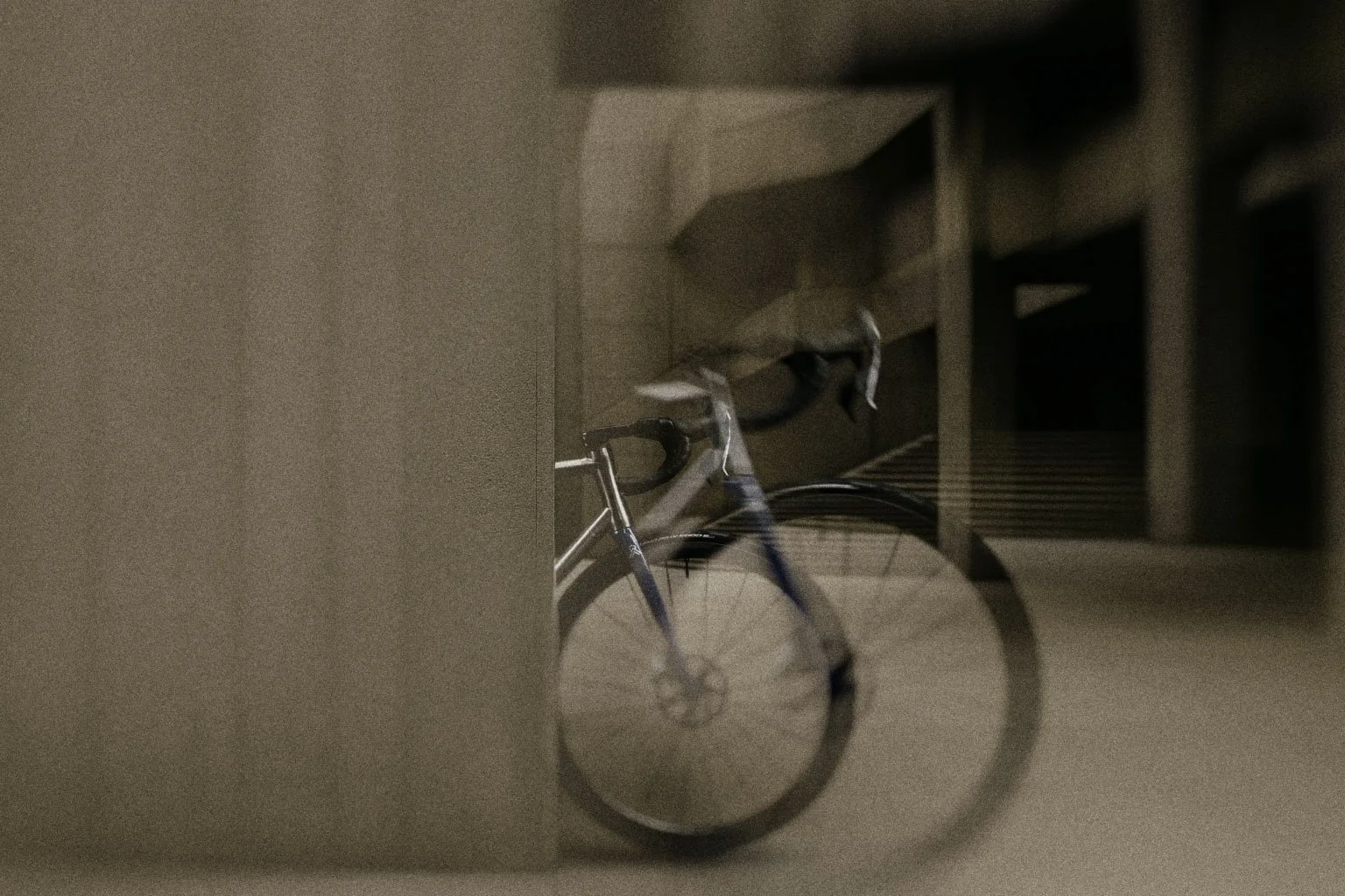 Una bicicleta apoyada en una pared en un espacio interior oscuro.