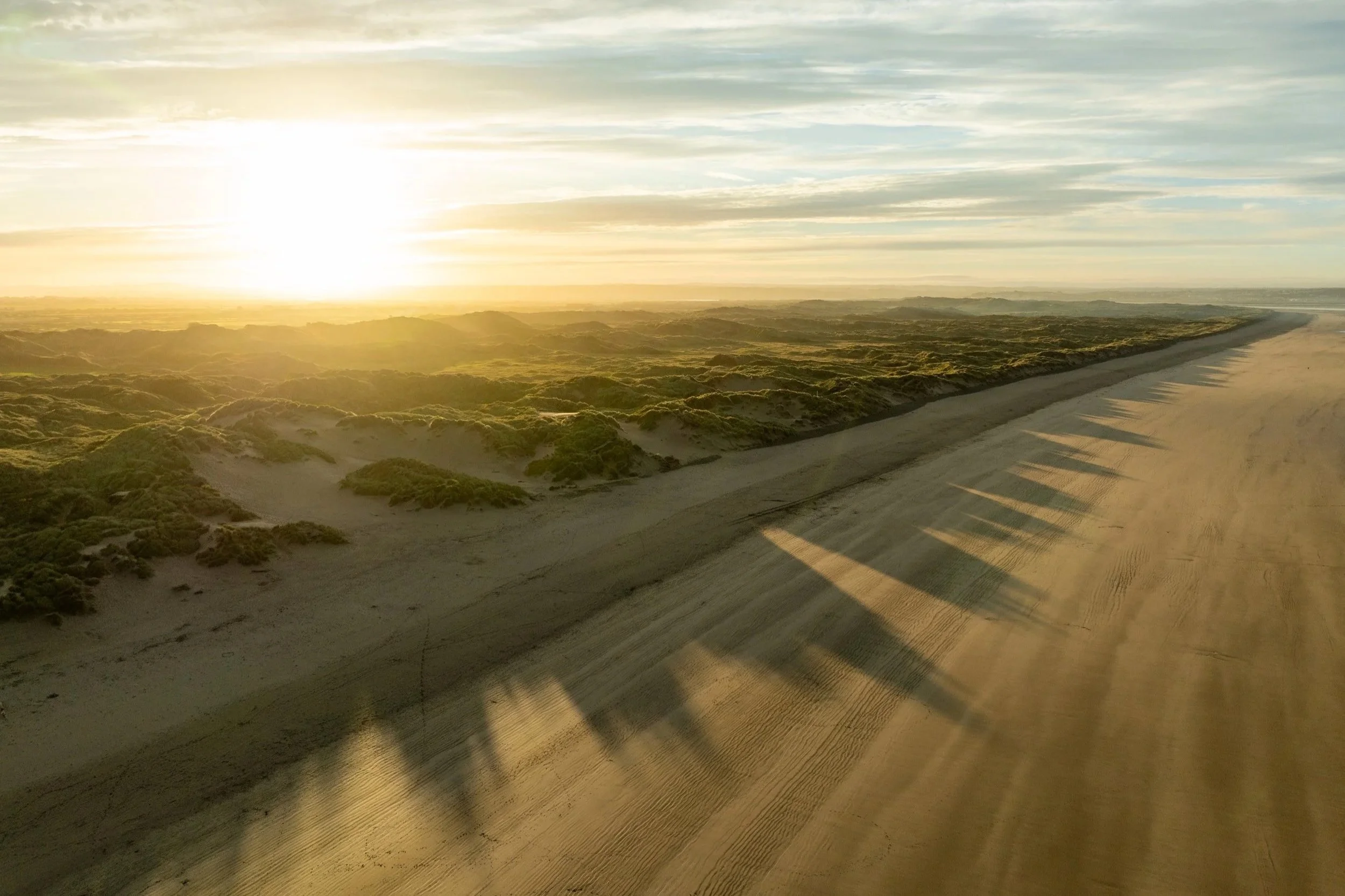 Beach landscape at sunset with sand dunes and shadows