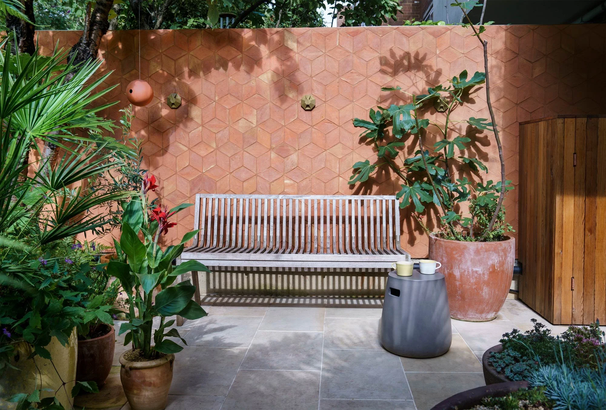 Orange wall with plants and a bench
