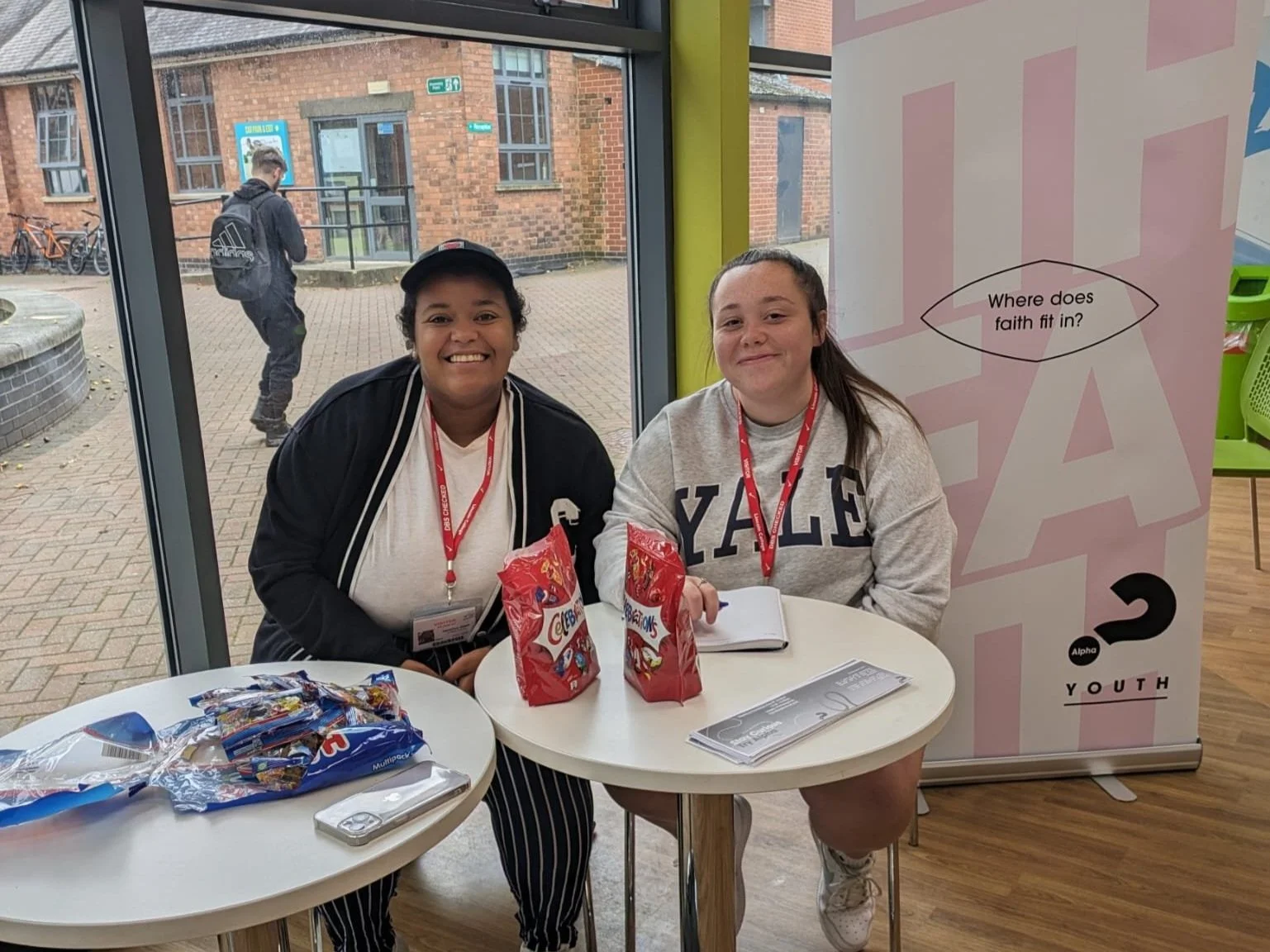 Two women sat down smiling at the camera