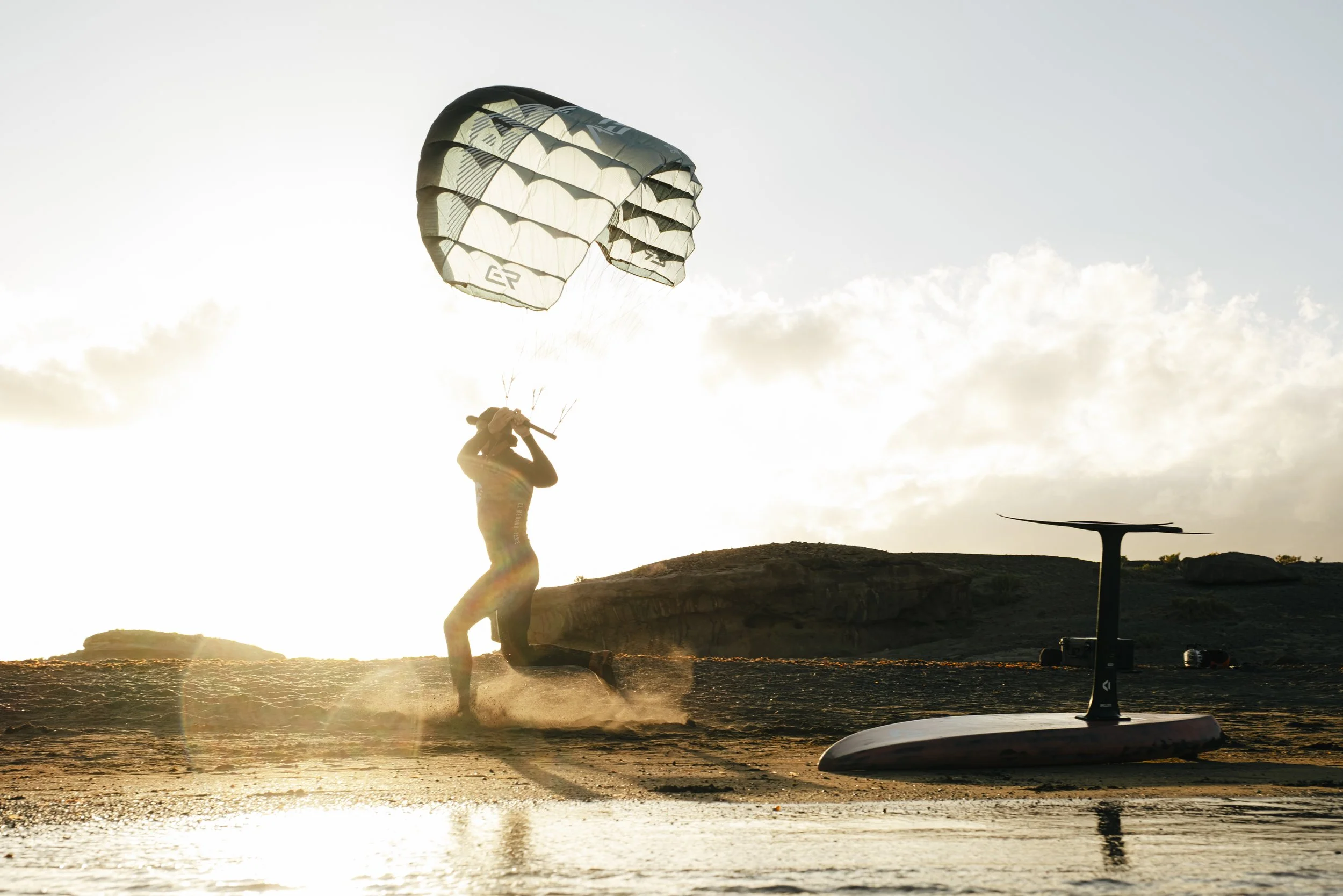 Rider using Aeryn parawing on foil board riding small waves in the ocean
