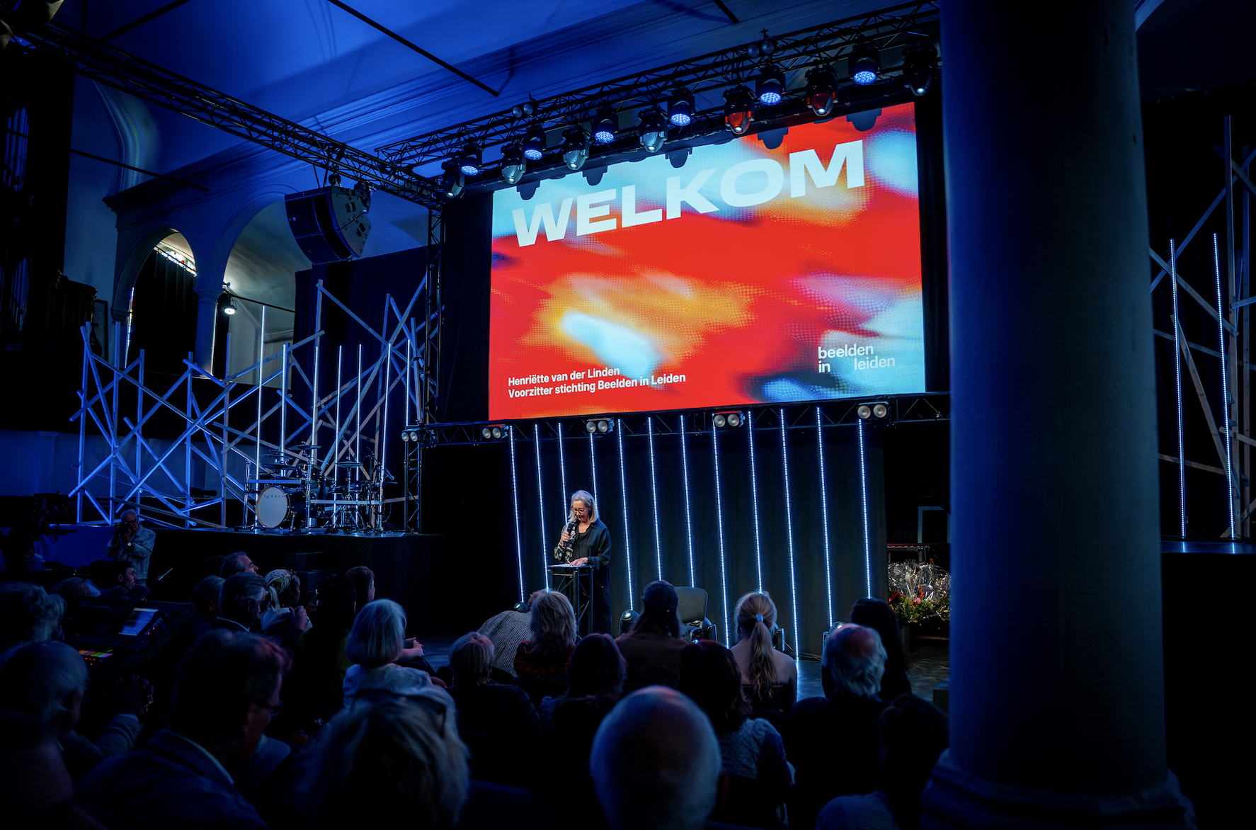 campagnebeeld ontwerp tentoonstelling in leiden groot scherm poster powerpoint in een zaal met mensen presentatie.
