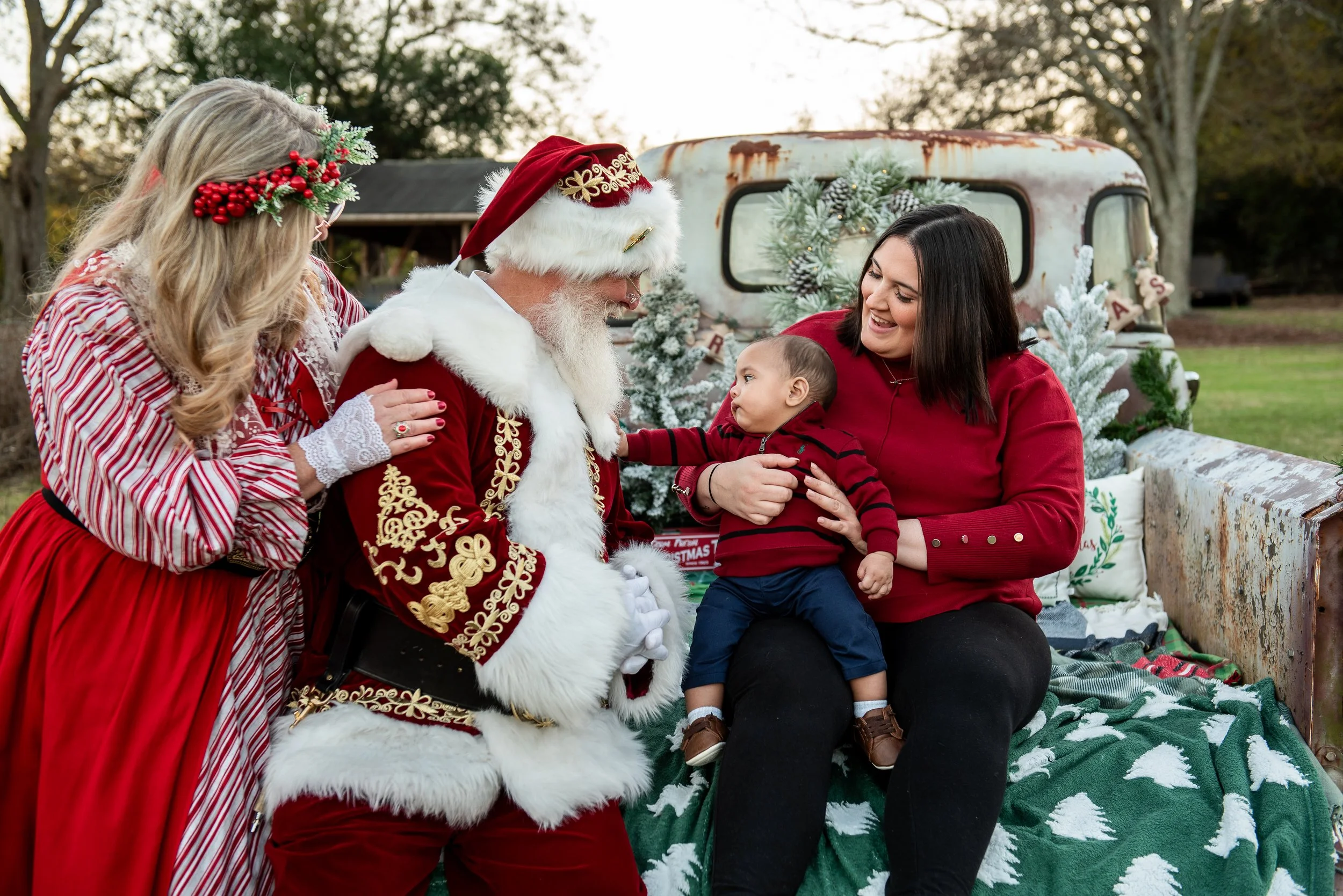 Santa and Mrs Claus with baby boy on old truck