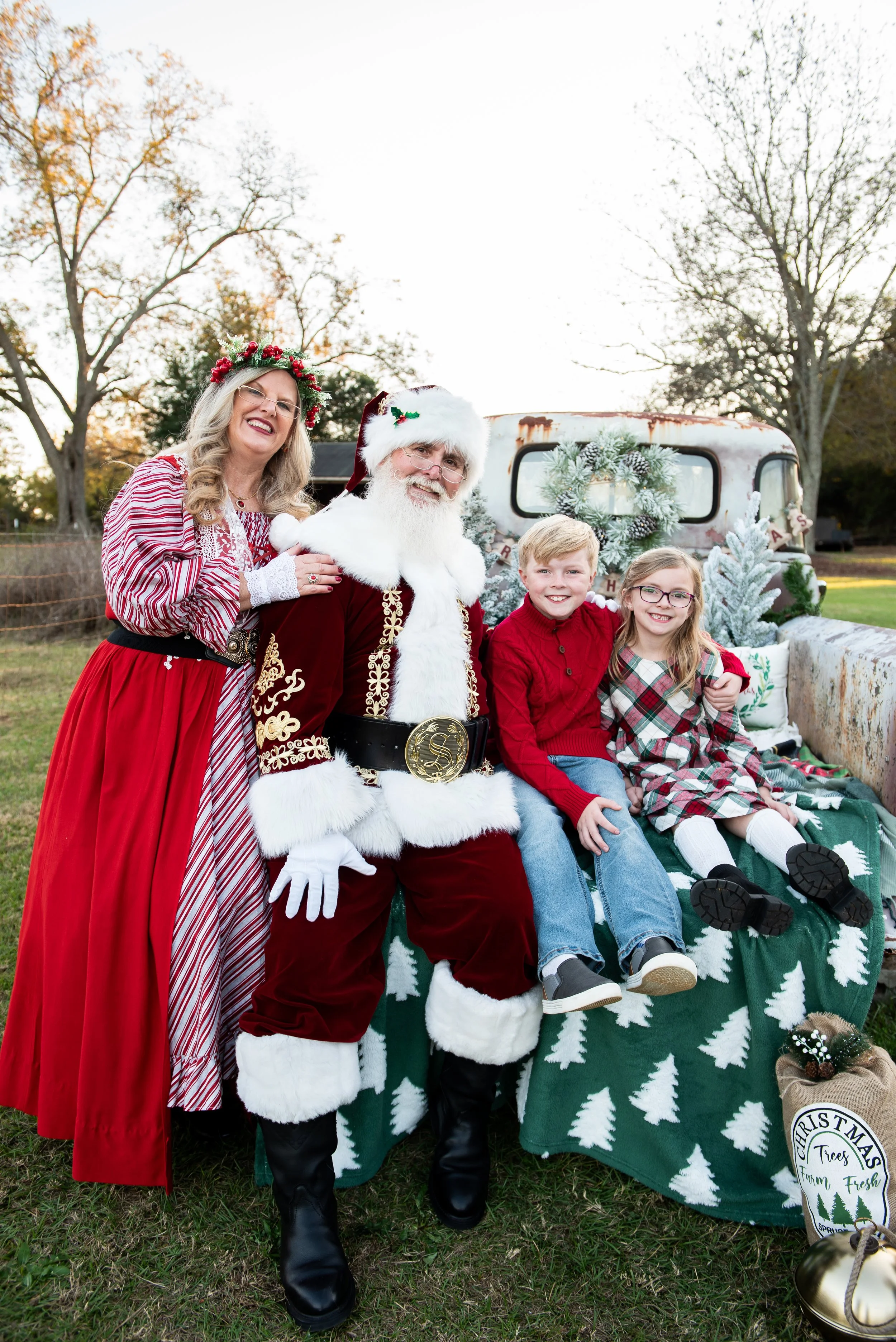 Santa and Mrs Claus with siblings on old truck