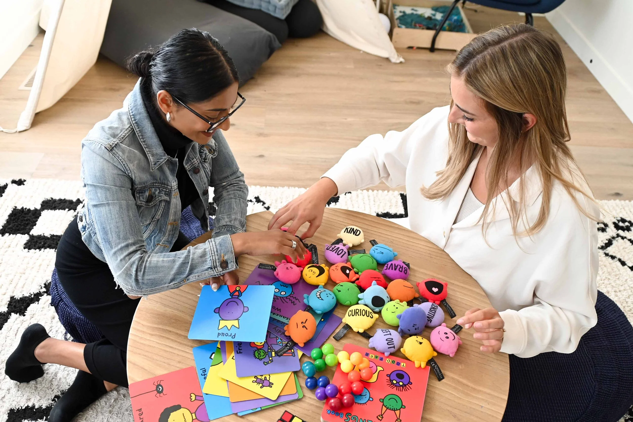 A child psychologist at Creative Sky Psychology in Calgary working with a young client at a table with colourful feelings toys and emotion cards.