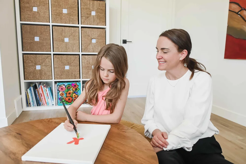 Child psychologist in Calgary sitting with a young girl during a therapy session at Creative Sky Psychology