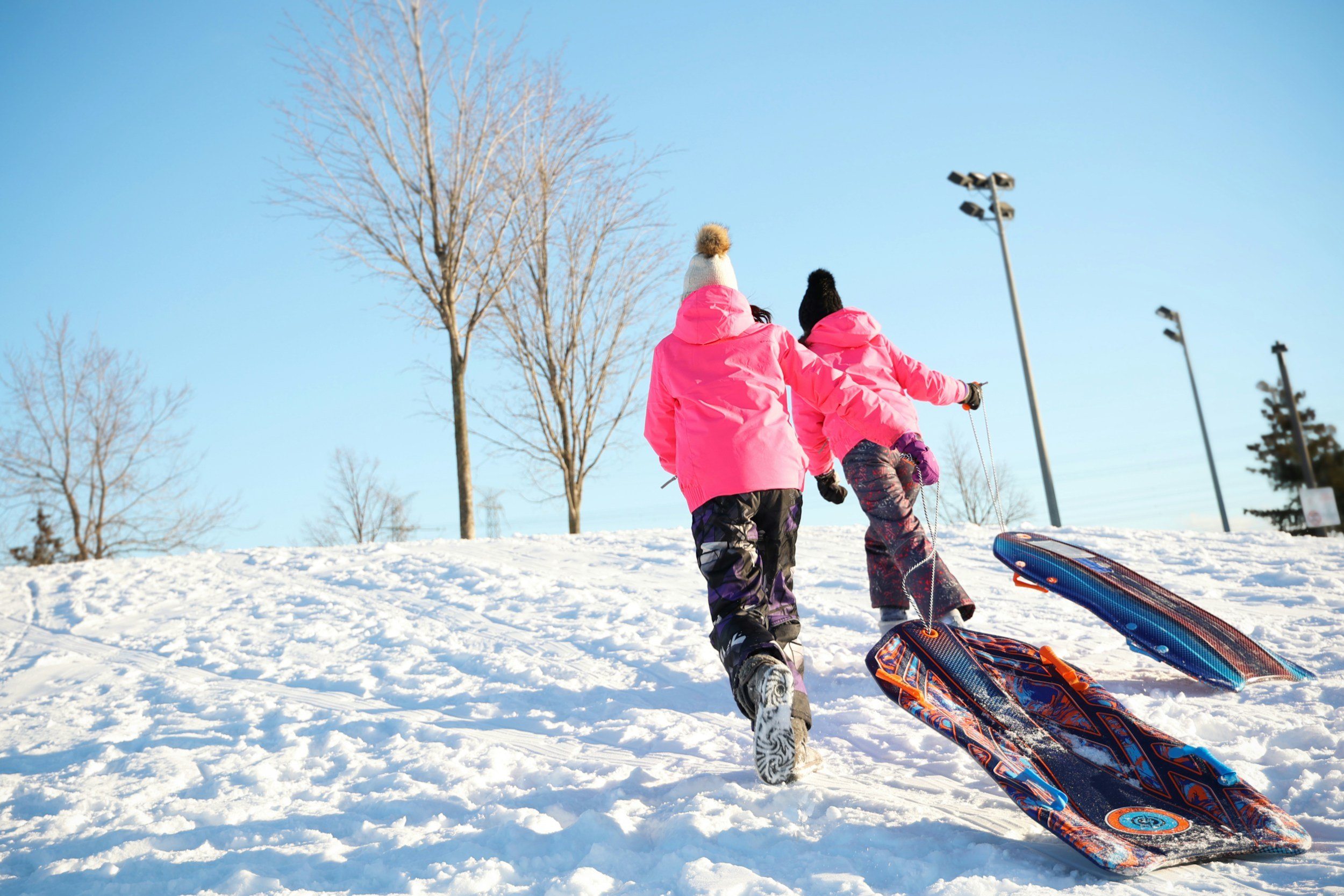"Children sledding in the snow on a sunny winter day, representing joyful outdoor activities that help improve mood and ease seasonal depression, Creative Sky Psychology."