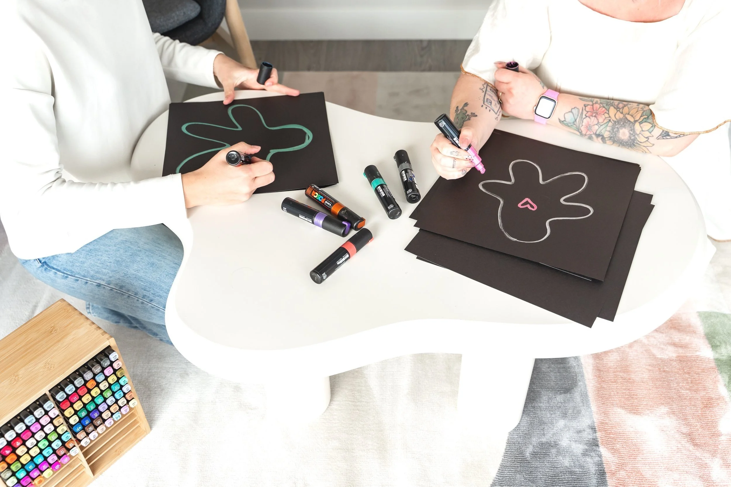A child and psychologist drawing together with markers on black paper during an art therapy session at Creative Sky Psychology in Calgary