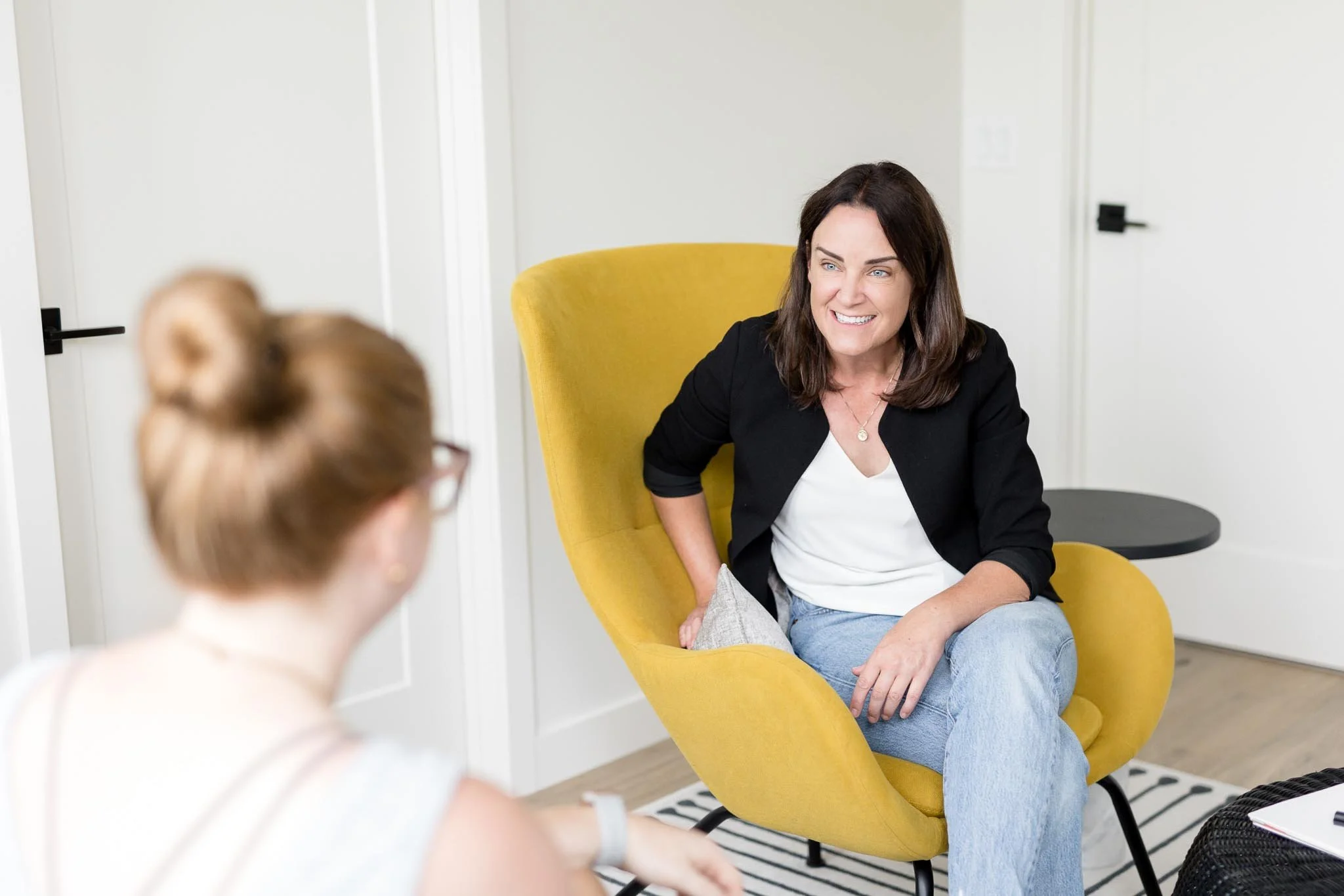 Child psychologist smiling warmly with a client during a therapy session at Creative Sky Psychology in Calgary