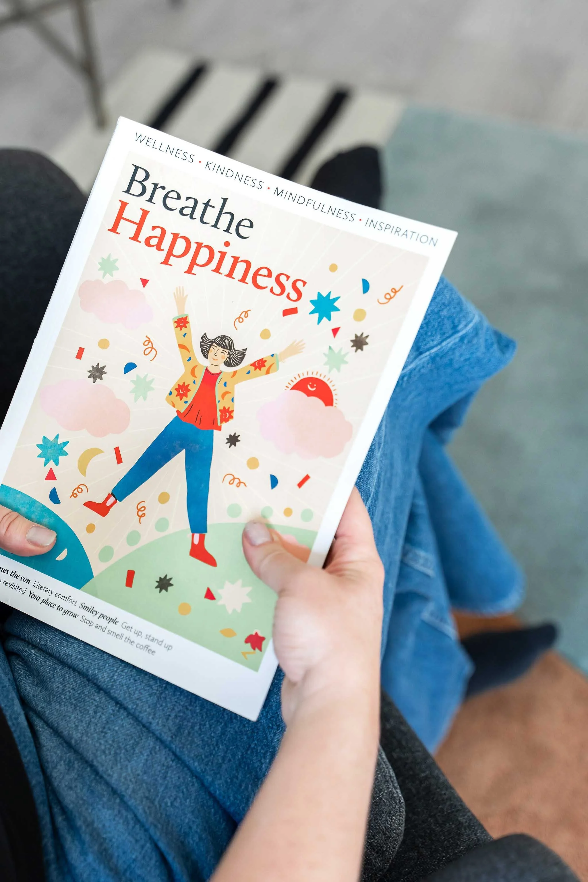 A child holding a colourful illustrated book about happiness and mindfulness during a session at Creative Sky Psychology in Calgary.