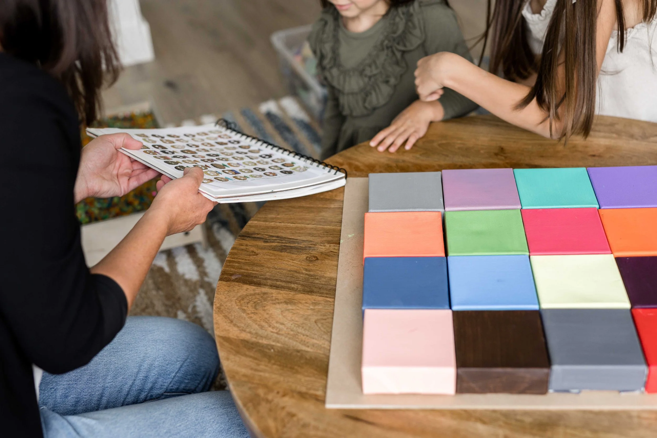 A child psychologist and child at a table with colourful building tiles and an activity board during a session at Creative Sky Psychology in Calgary.