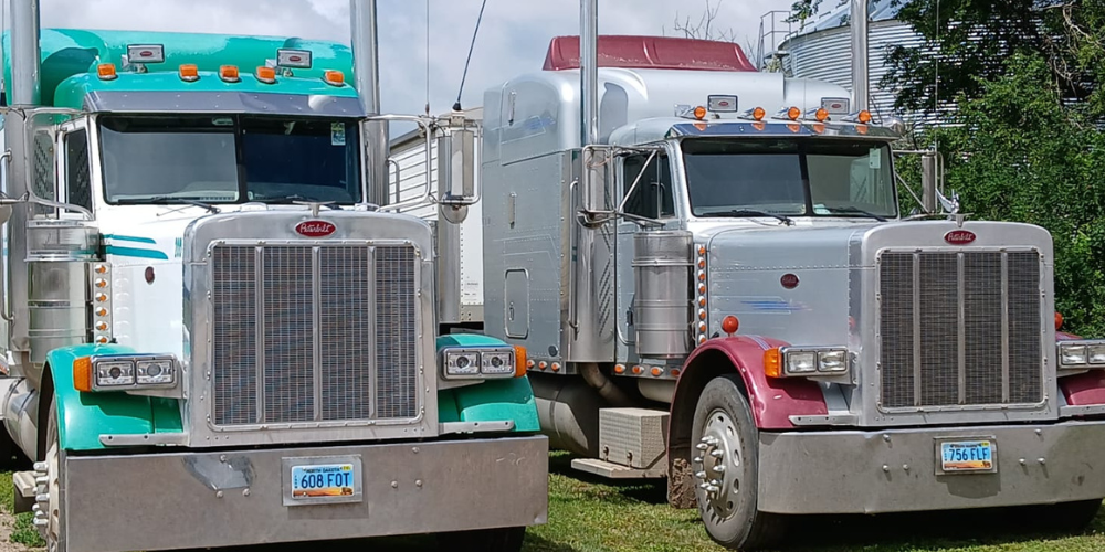 image of two farm trucks for H2A farm truck drivers
