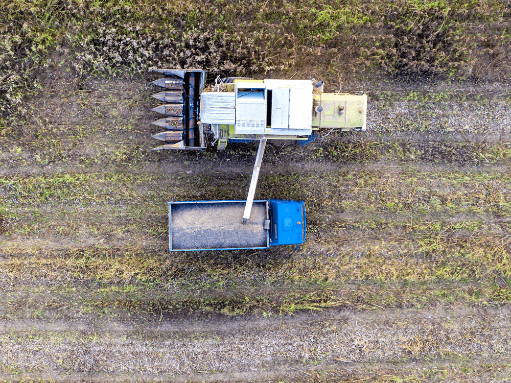 overhead image of combine filling grain truck with grains and crops