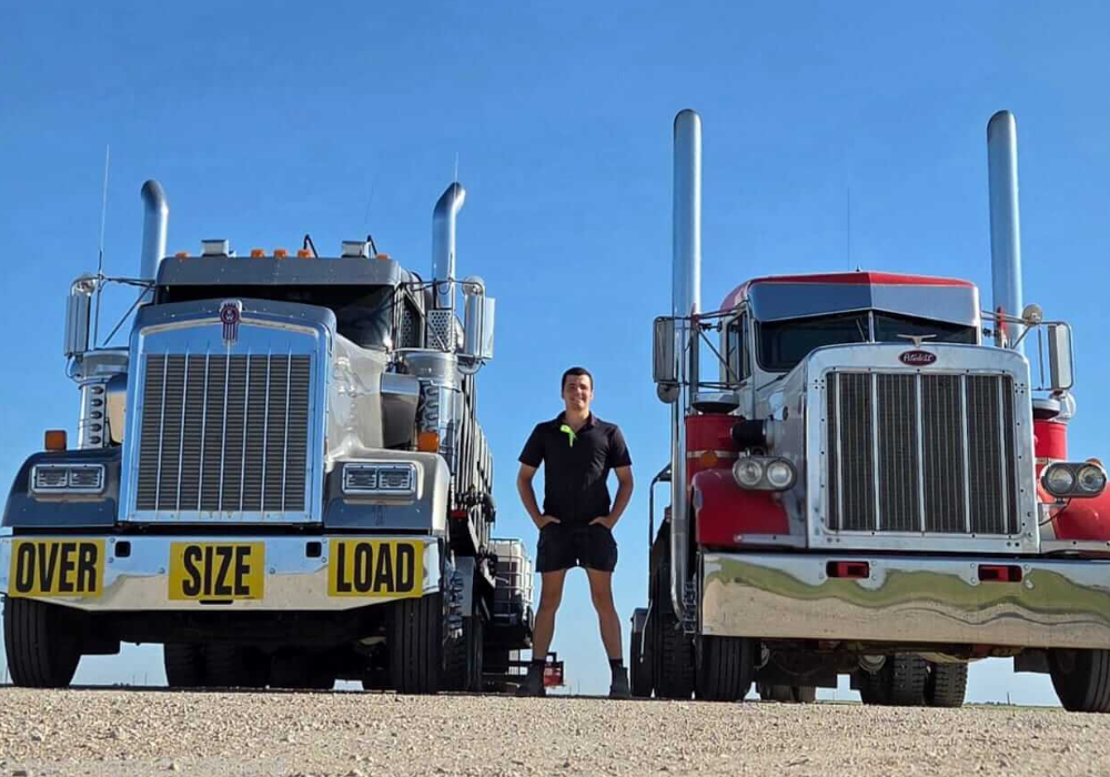 image of h2a worker in america succeeding despite being homesick standing between two semis