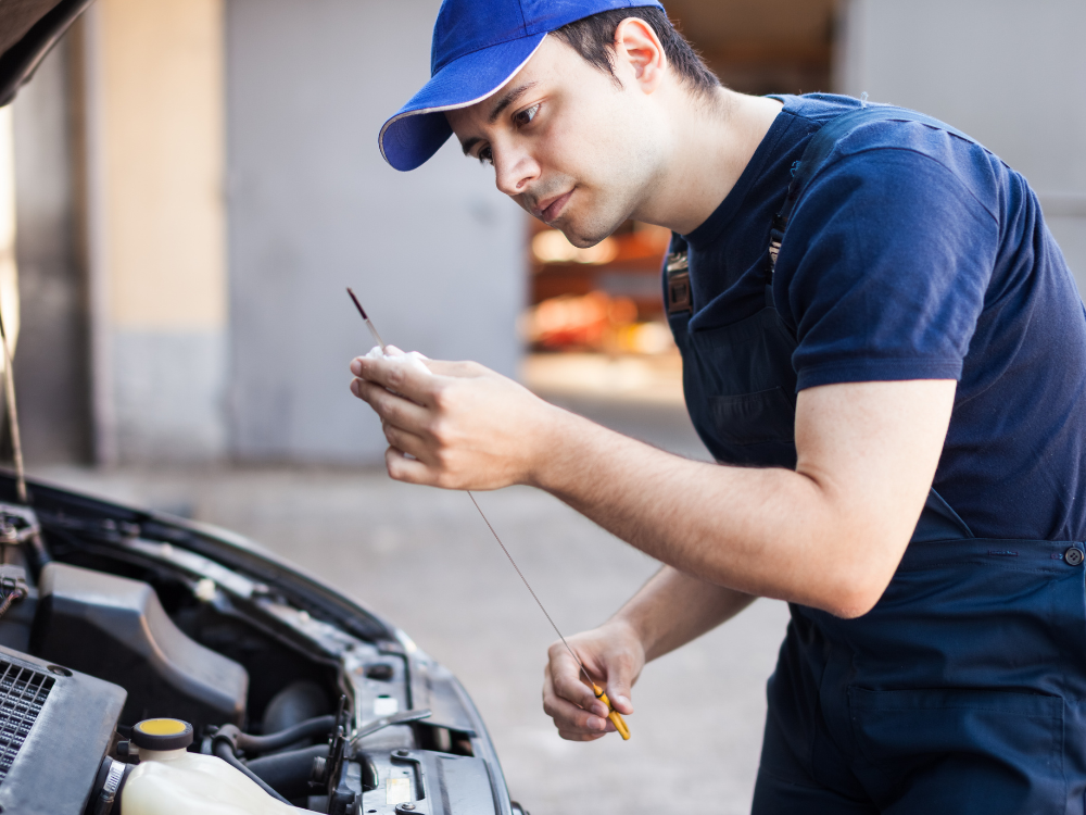 picture of H2A farm driver checking the oil on a truck for routine maintenance