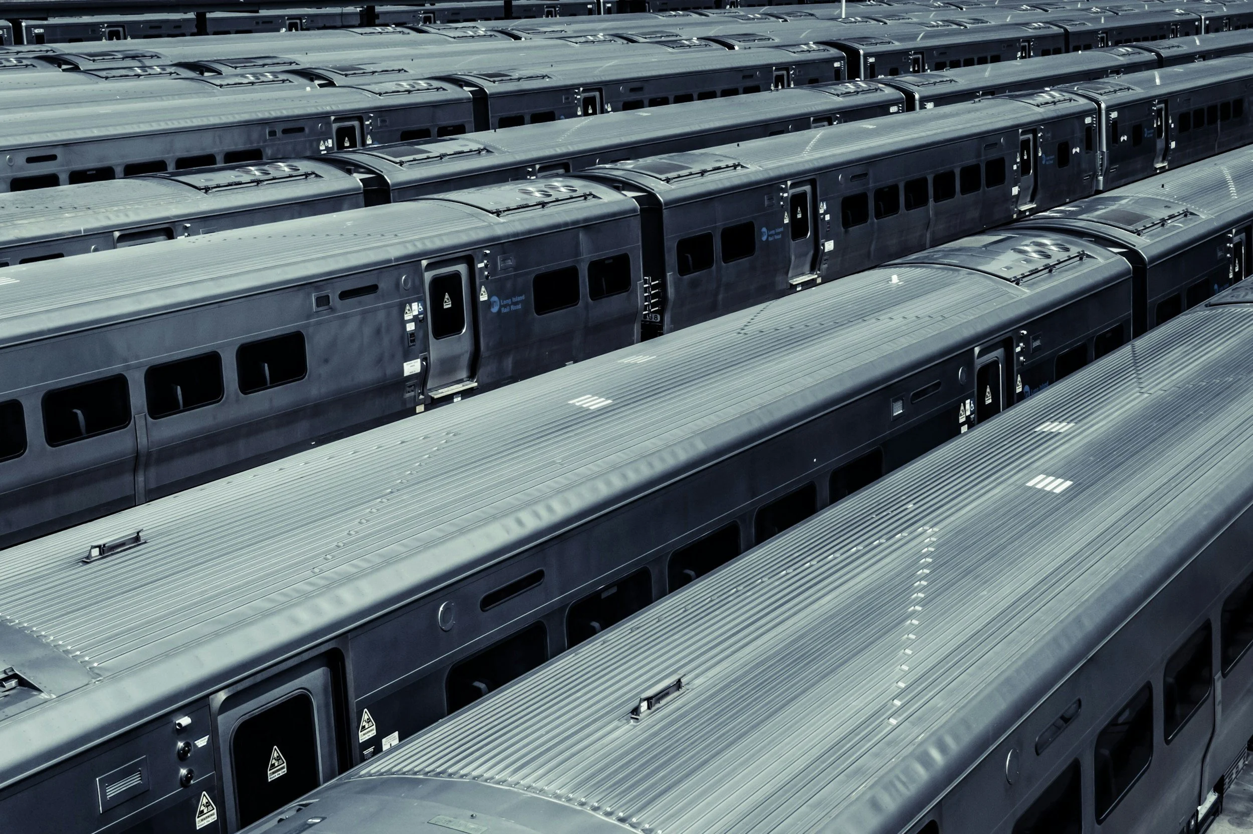 multiple train cars parked in a rail yard