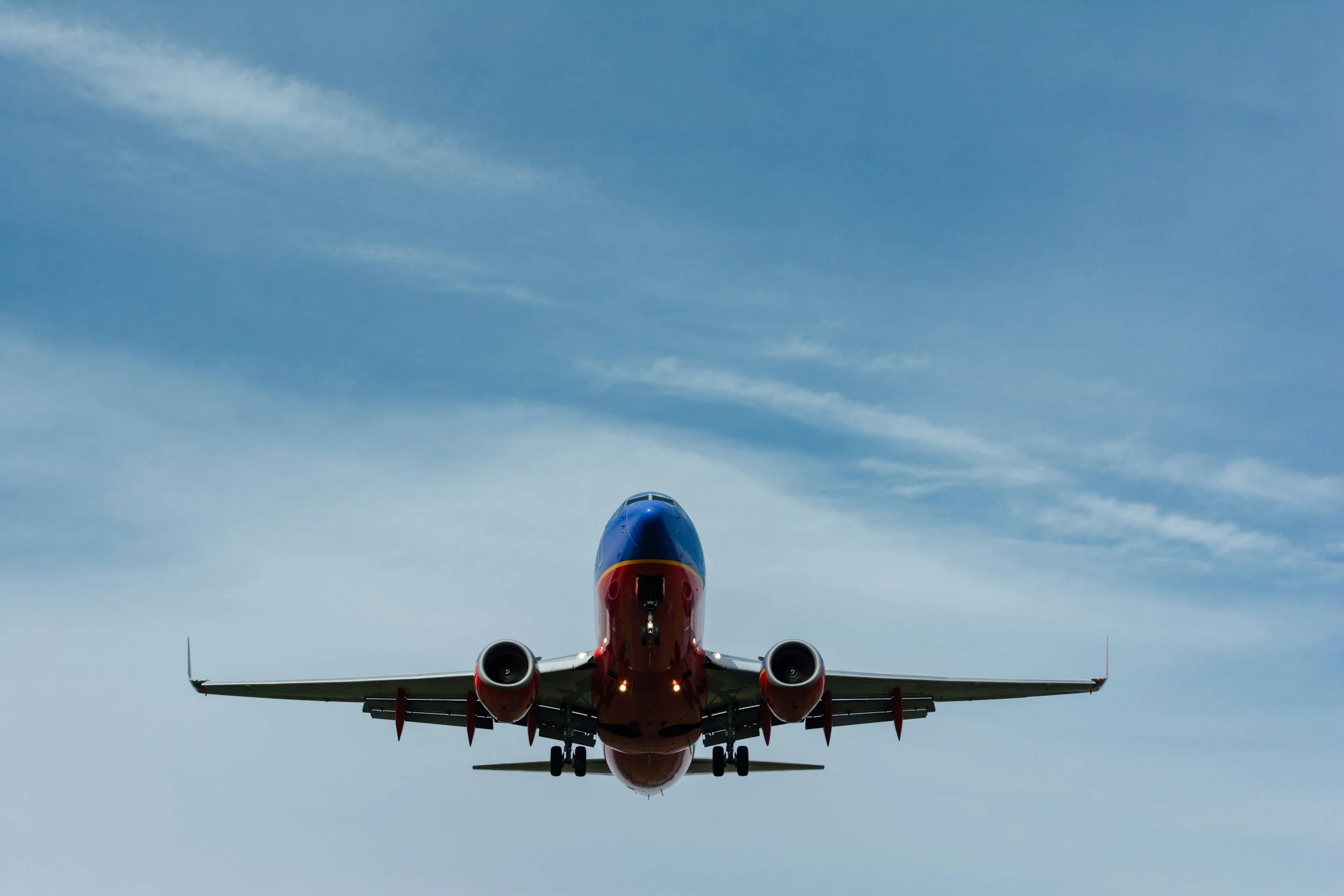 Airplane flying overhead against blue sky.