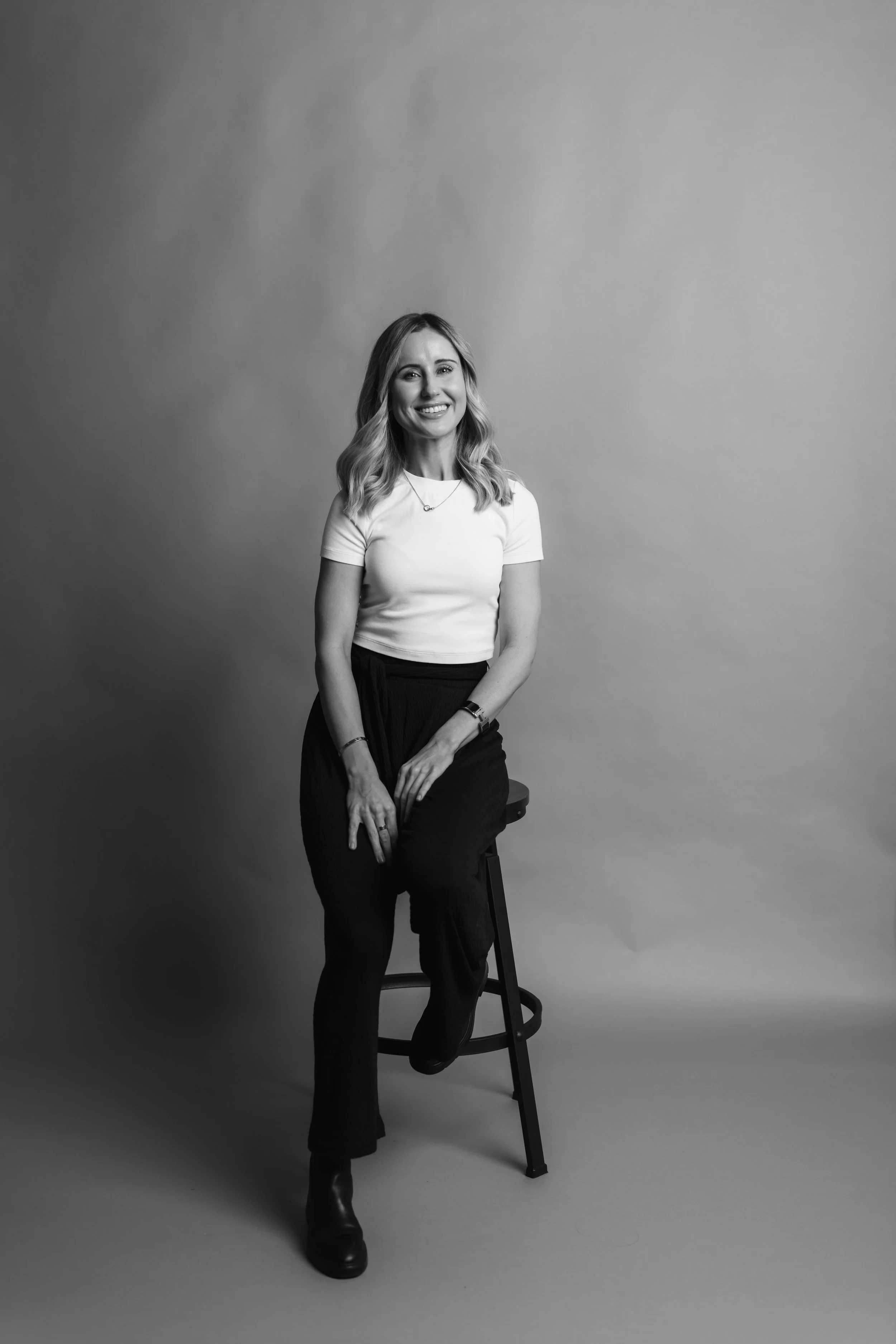 Los Angeles Female Therapist Abby Wilson is sitting in a stool and smiling