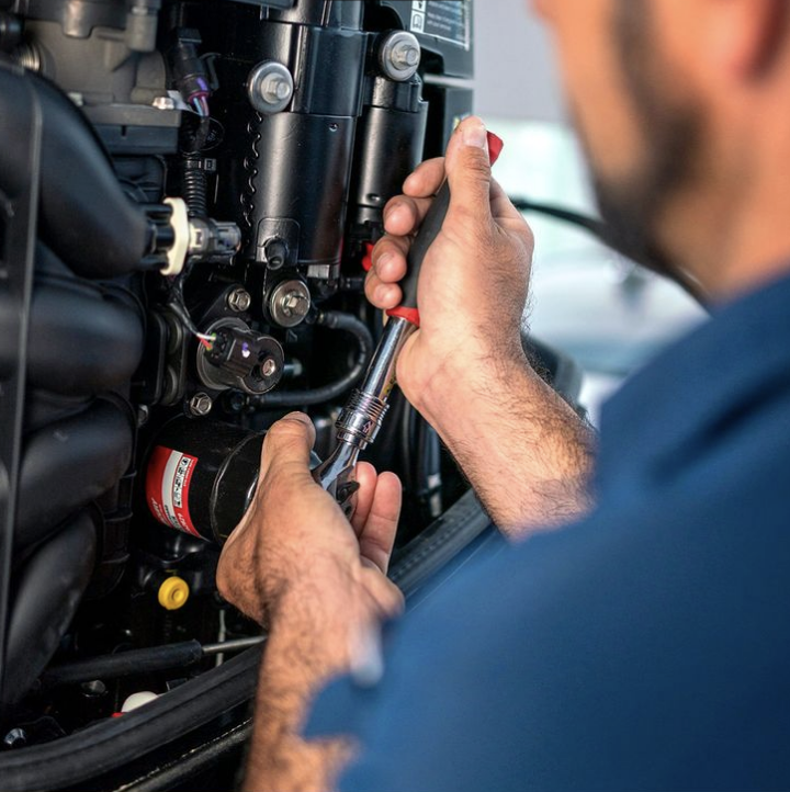 A marine mechanic winterizing an inboard boat engine.