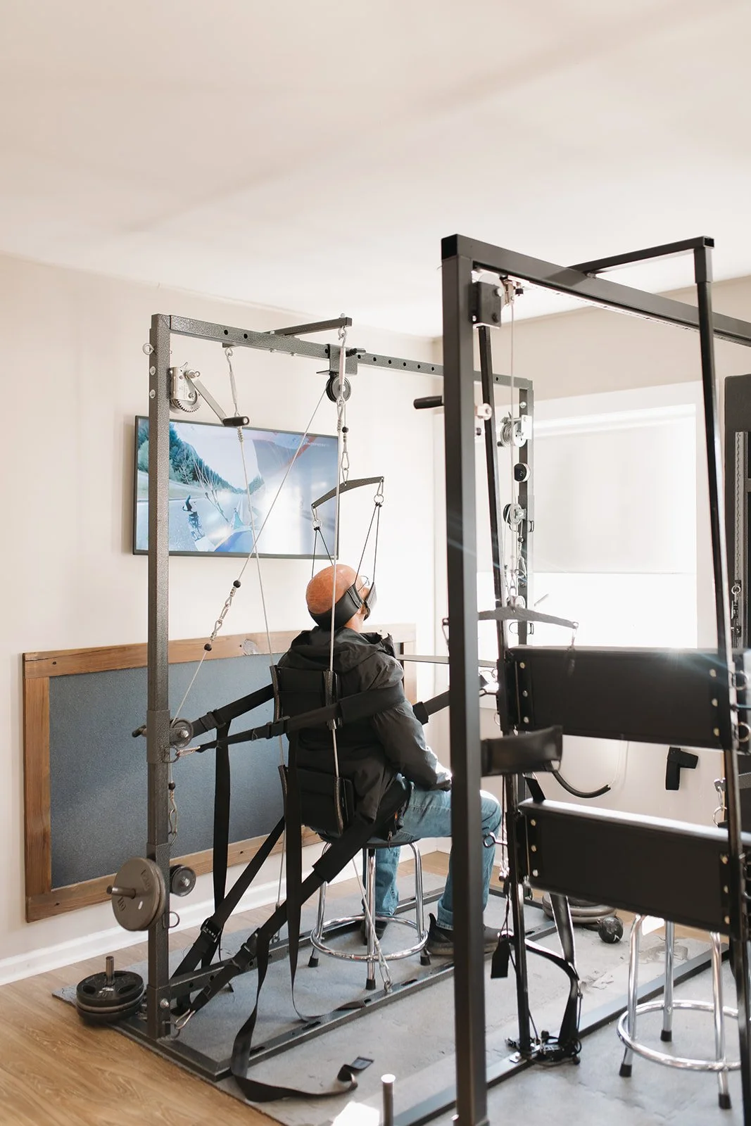 Person sitting on a chair with a harness system in a chiropractic office, using traction to reduce neck and back pain.