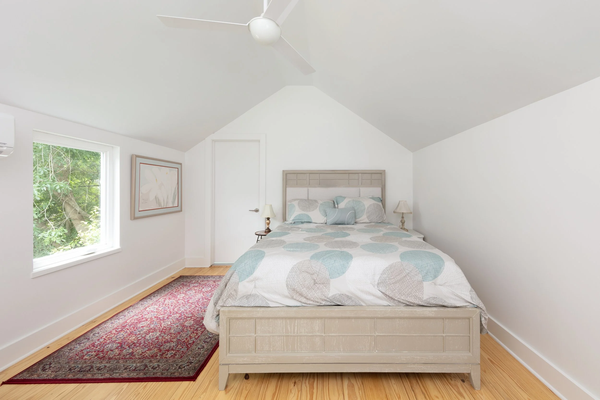 Room with a double bed and white walls