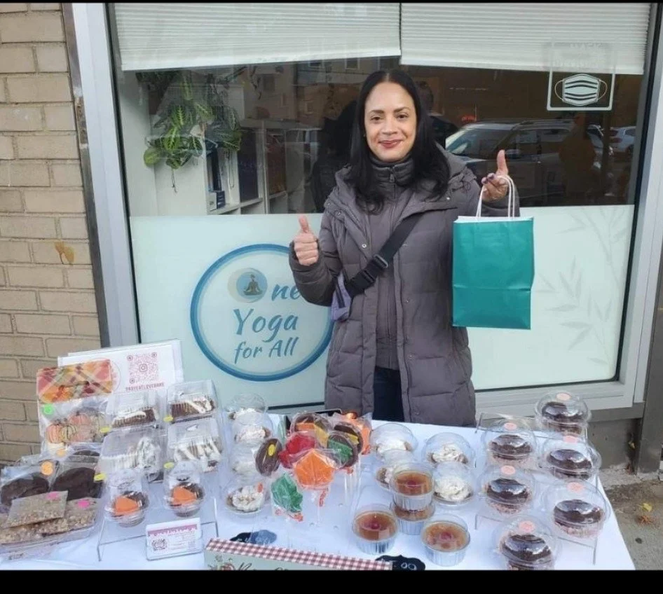 Peggy Garcia holding a blue bag  behind a dessert display table