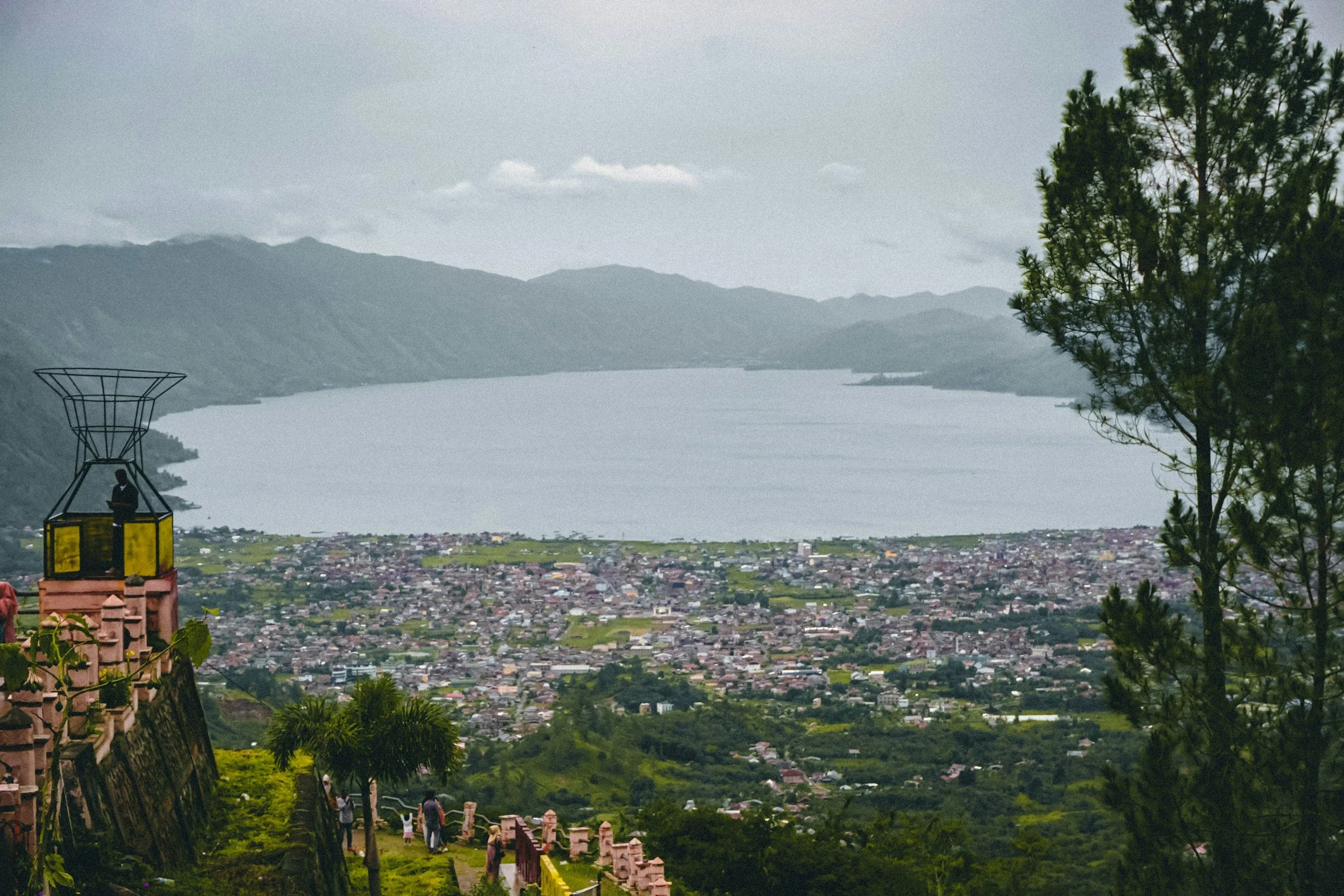 Photograph of Indonesian town along the coast with mountains in the background