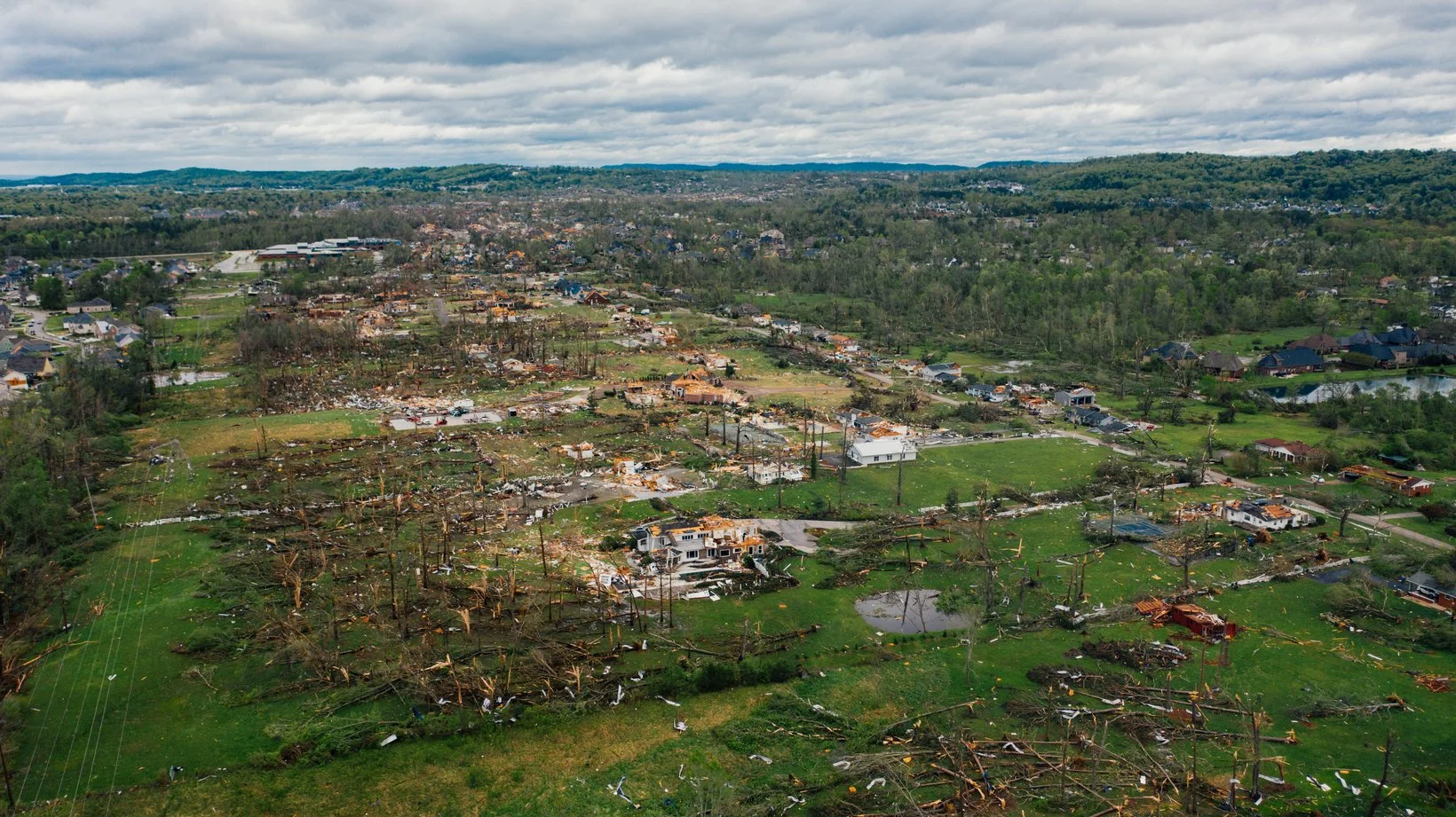 Aerial view of rural area in Chattanooga, Tennessee showing the aftermath of a destructive storm with many trees blown over and houses destroyed.