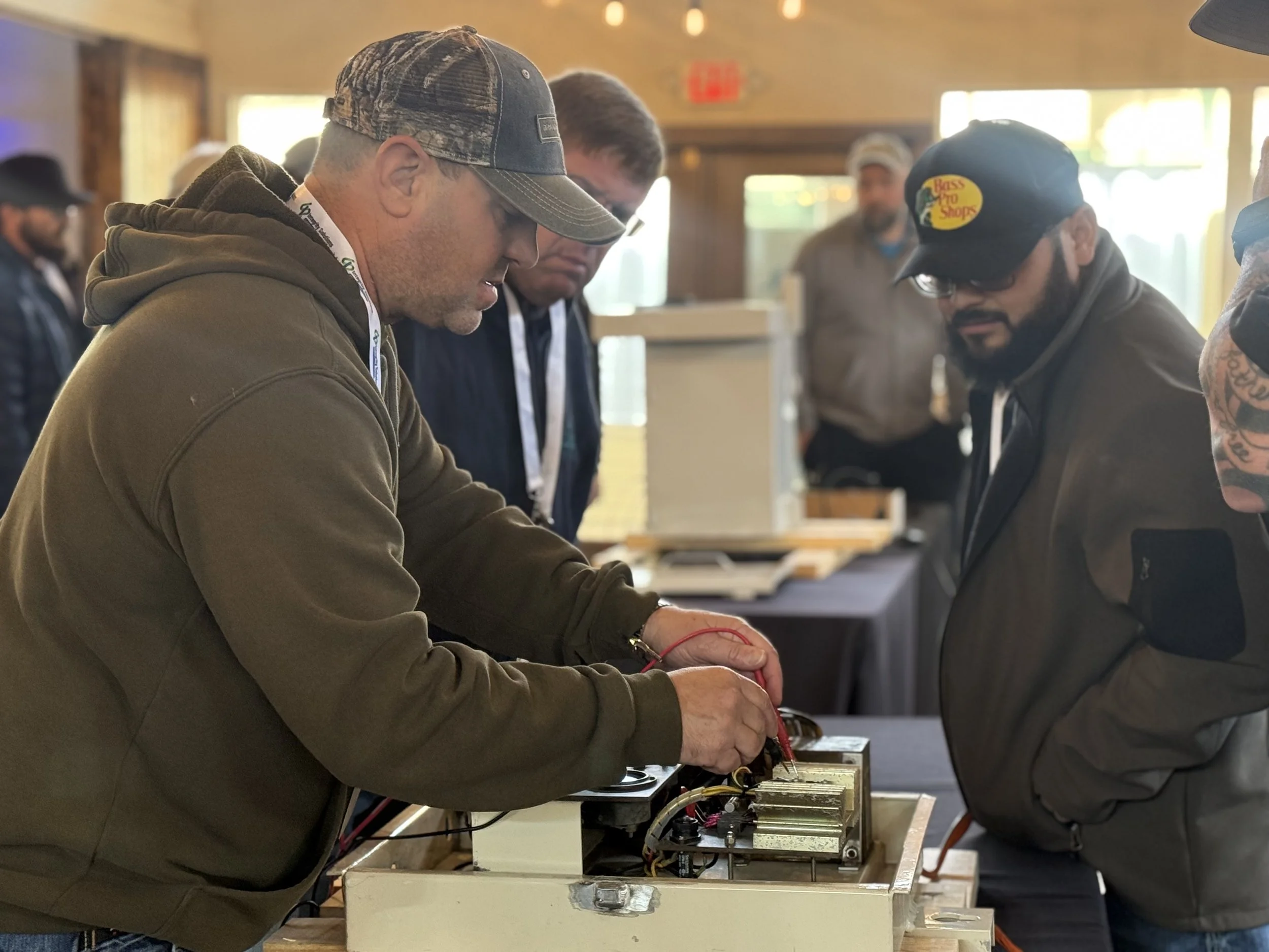 People working on electronic equipment at an indoor event