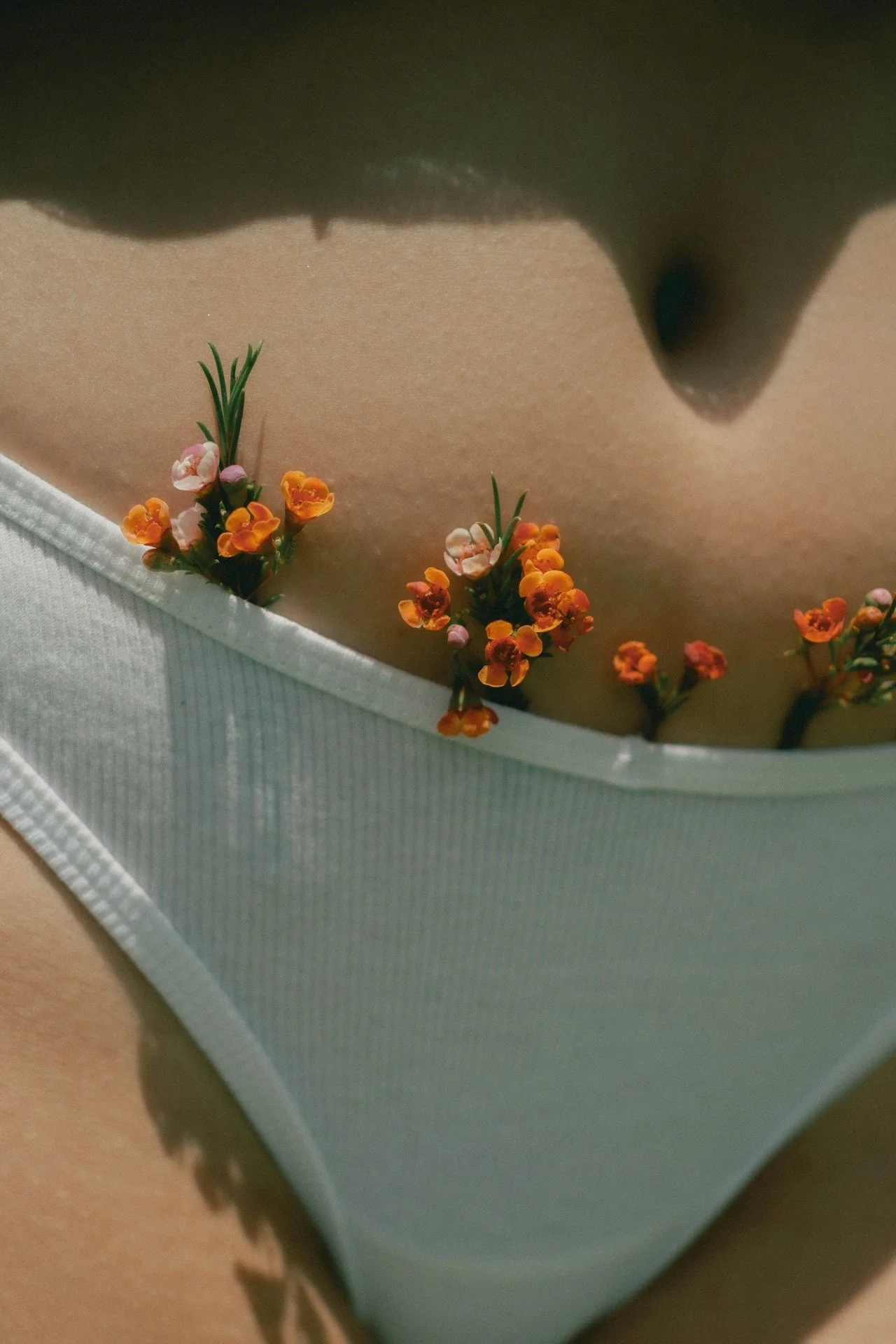 flowers tucked into white underwear — spring intimacy reset and sensual self care
