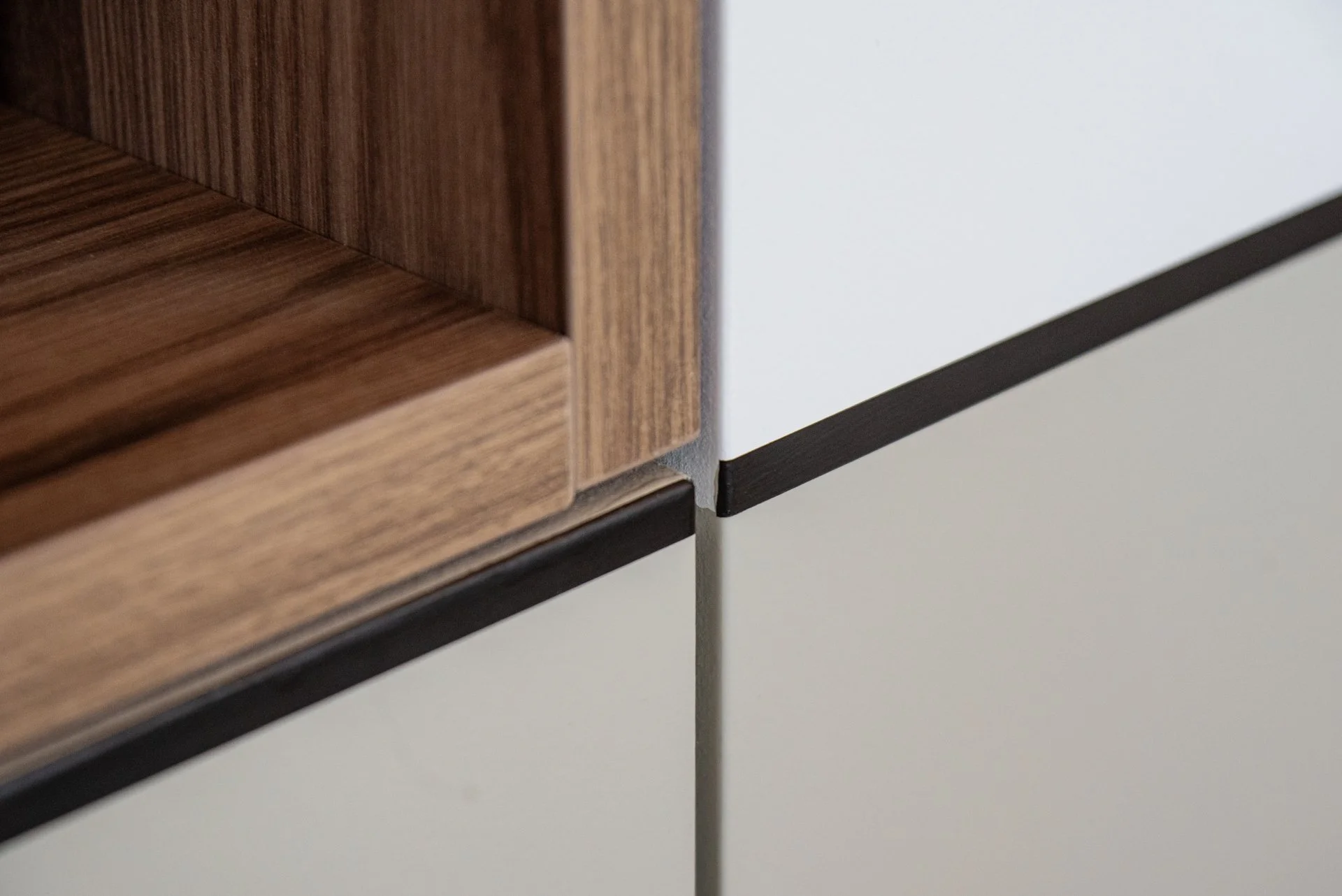 Zoom su l'angolo di un mobile con dettagli di finitura, mostra superfici in legno e componenti in metallo.