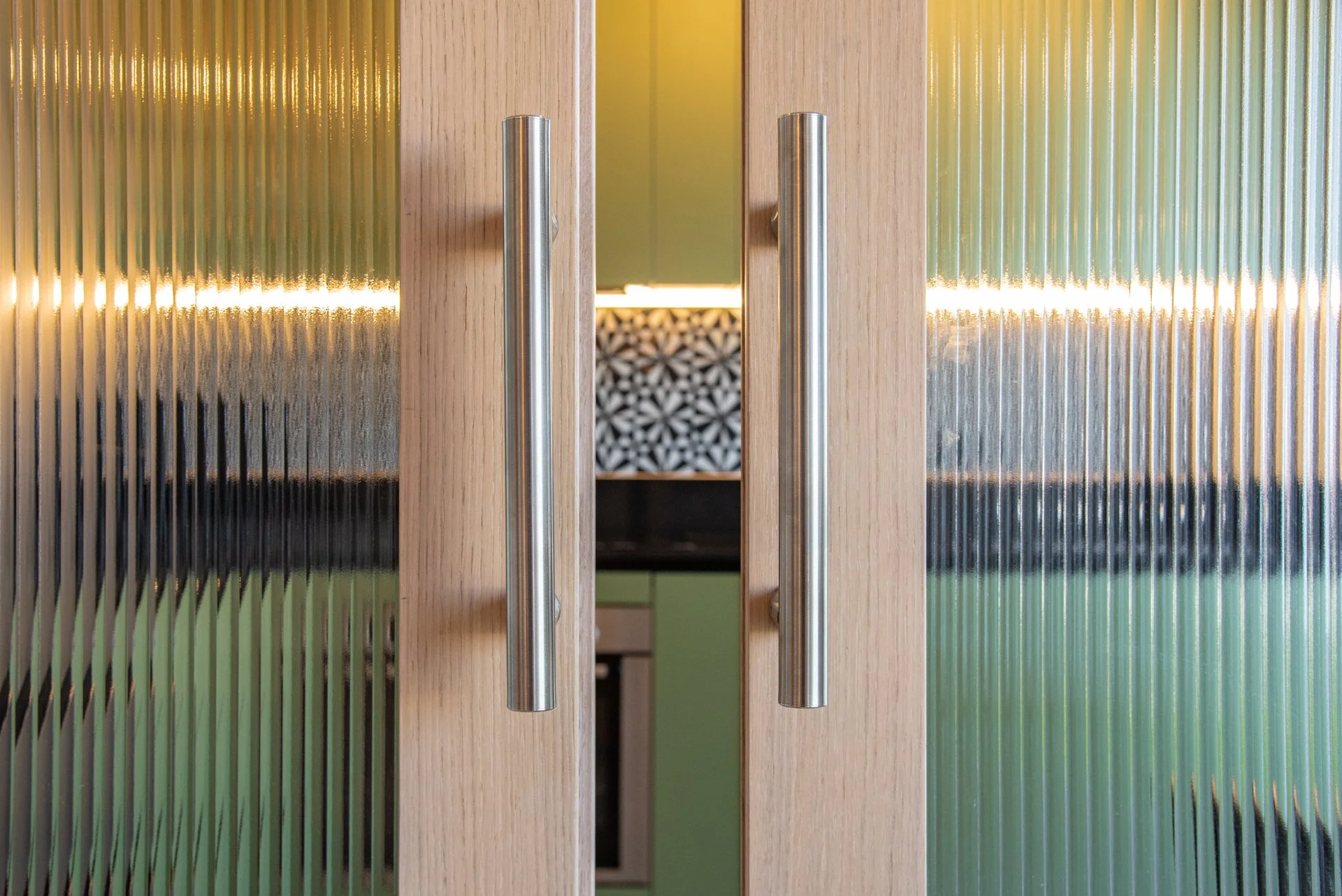 porta in legno con maniglie in acciaio e vetri smerigliati sui lati