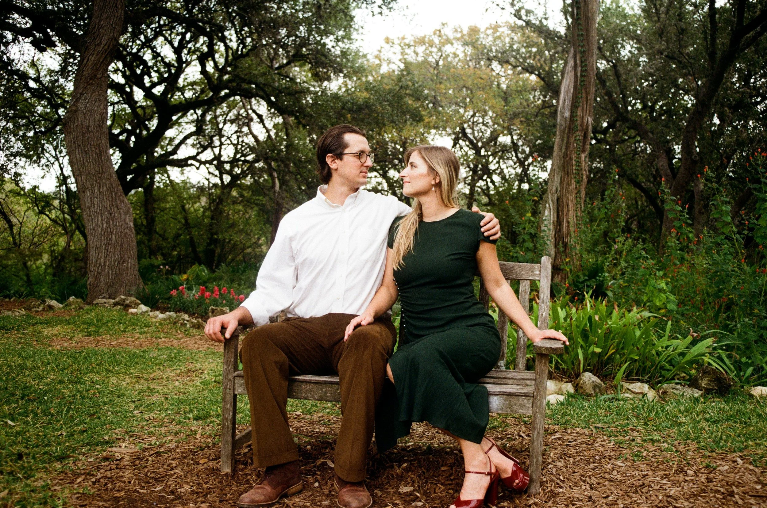 Couple sits on bench in garden