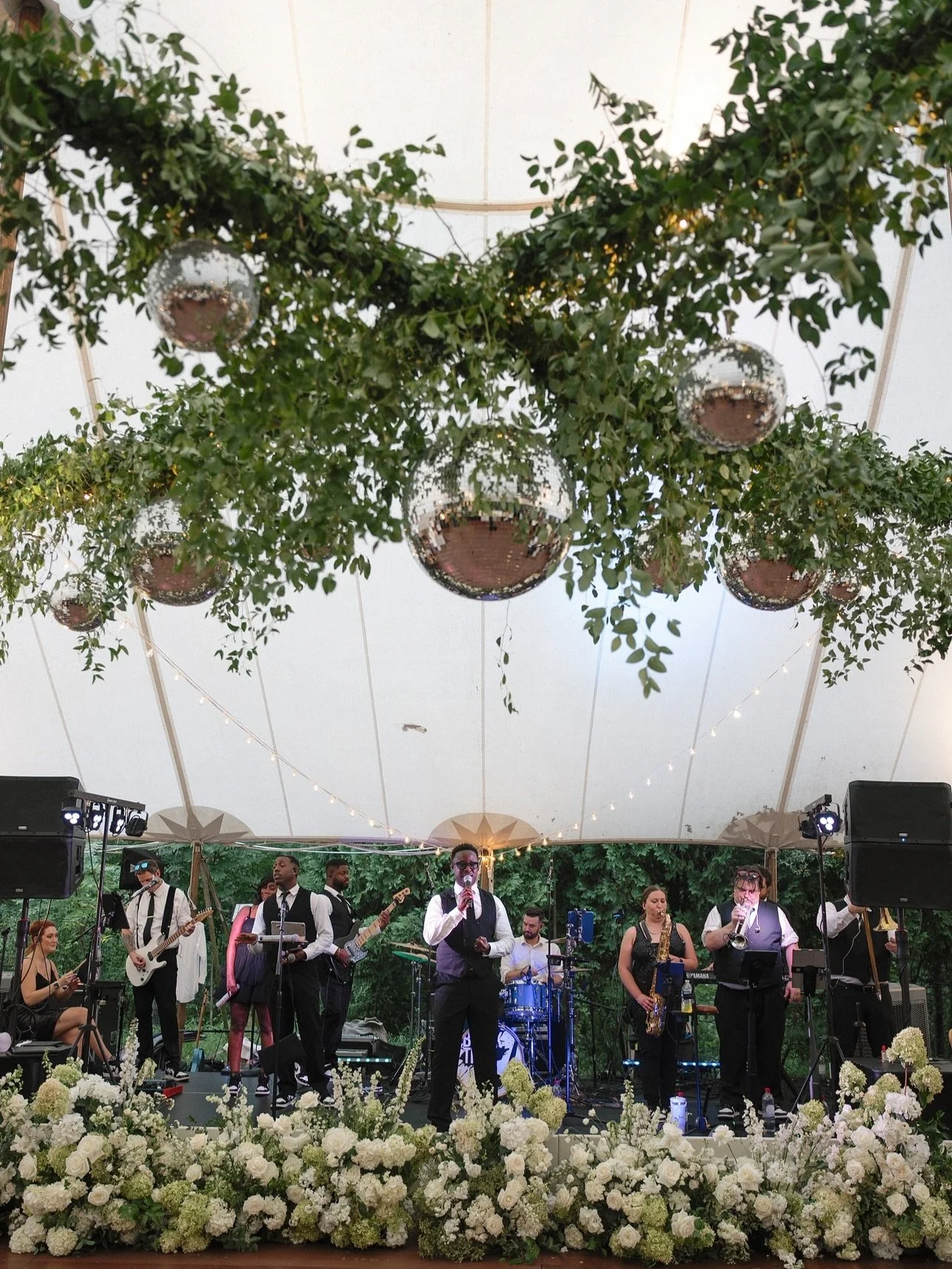 If the dance floor had a dress code, this would be it.

Hanging greenery, glimmering disco balls, and florals tucked where you least expect them. This install brought the energy, and gave the couple the overhead moment they were dreaming of.

Plannin