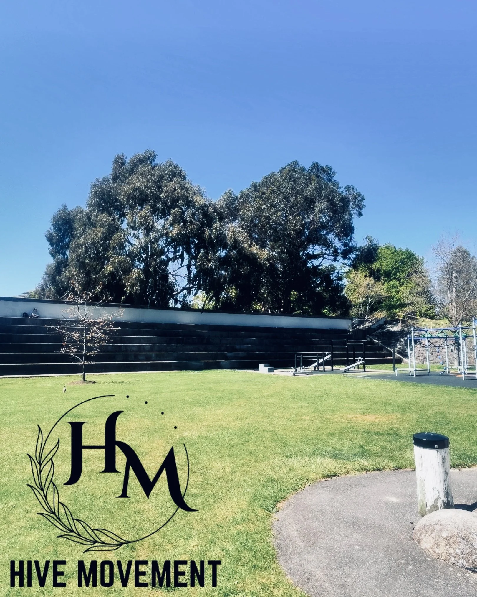 Outdoor park with green lawn, pathway, trees, and Hive Movement logo