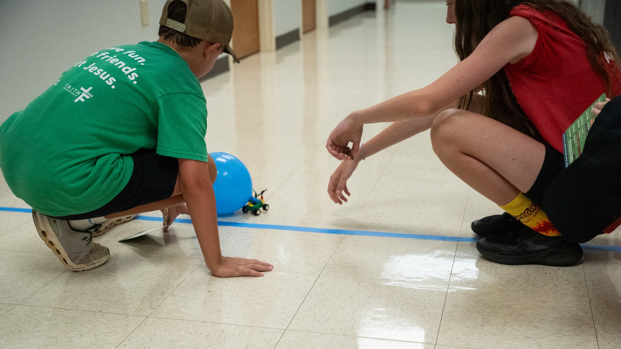 A blue race car with the number 53 is moving at high speed on a racetrack, with a blurred background indicating motion.