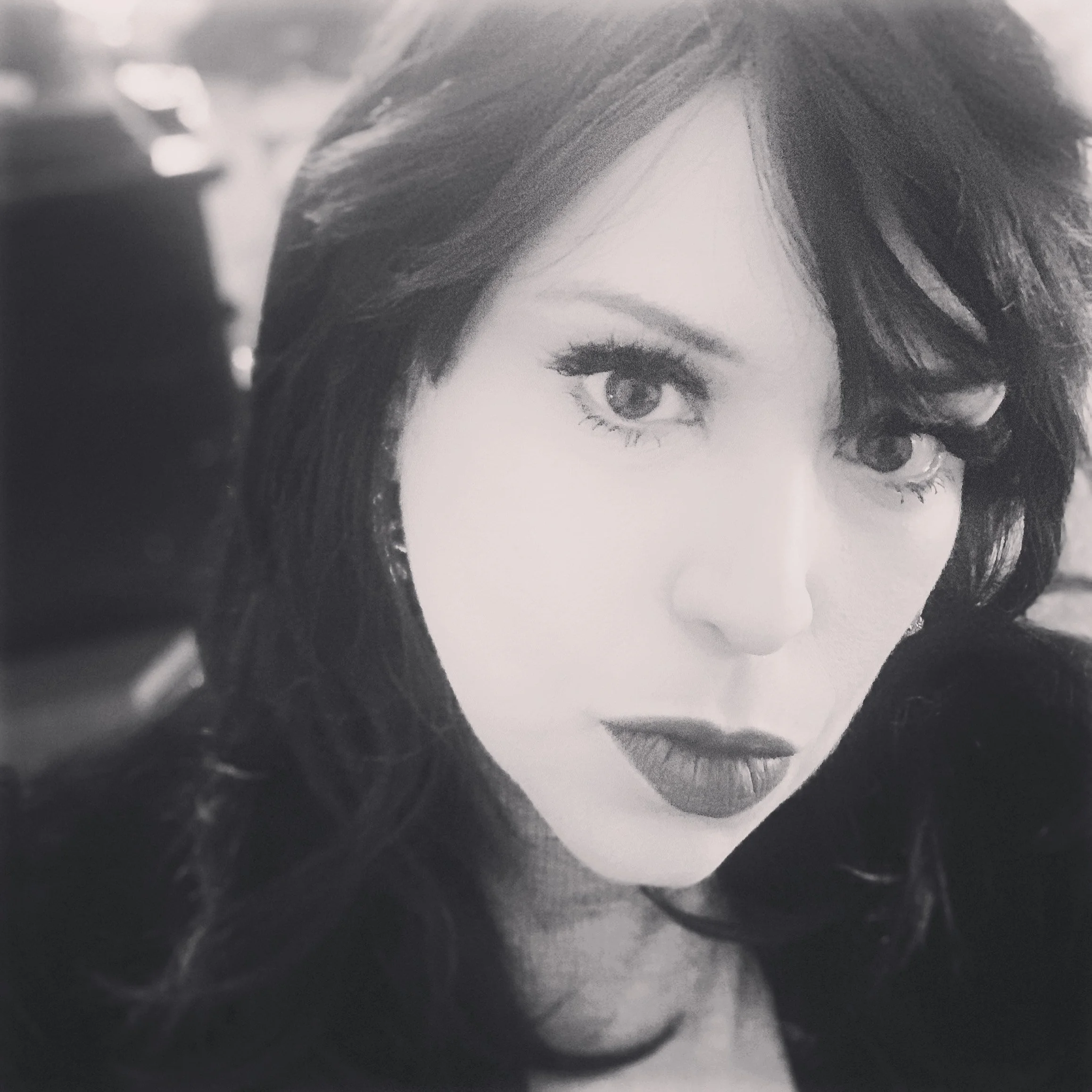 Close-up of a person's face, focusing on one eye and part of the hairstyle, black-and-white photo.