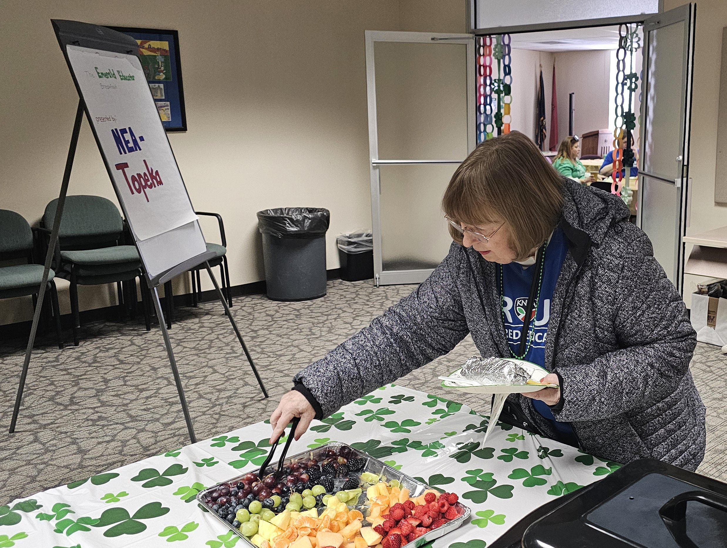   PHOTO BY ANN MARIE BUSH/KNEA    KNEA-Retired President Sherry Turnbull grabbed some food at the Emerald Educator Breakfast hosted by NEA-Topeka before heading to the rally on Tuesday, March 17.  