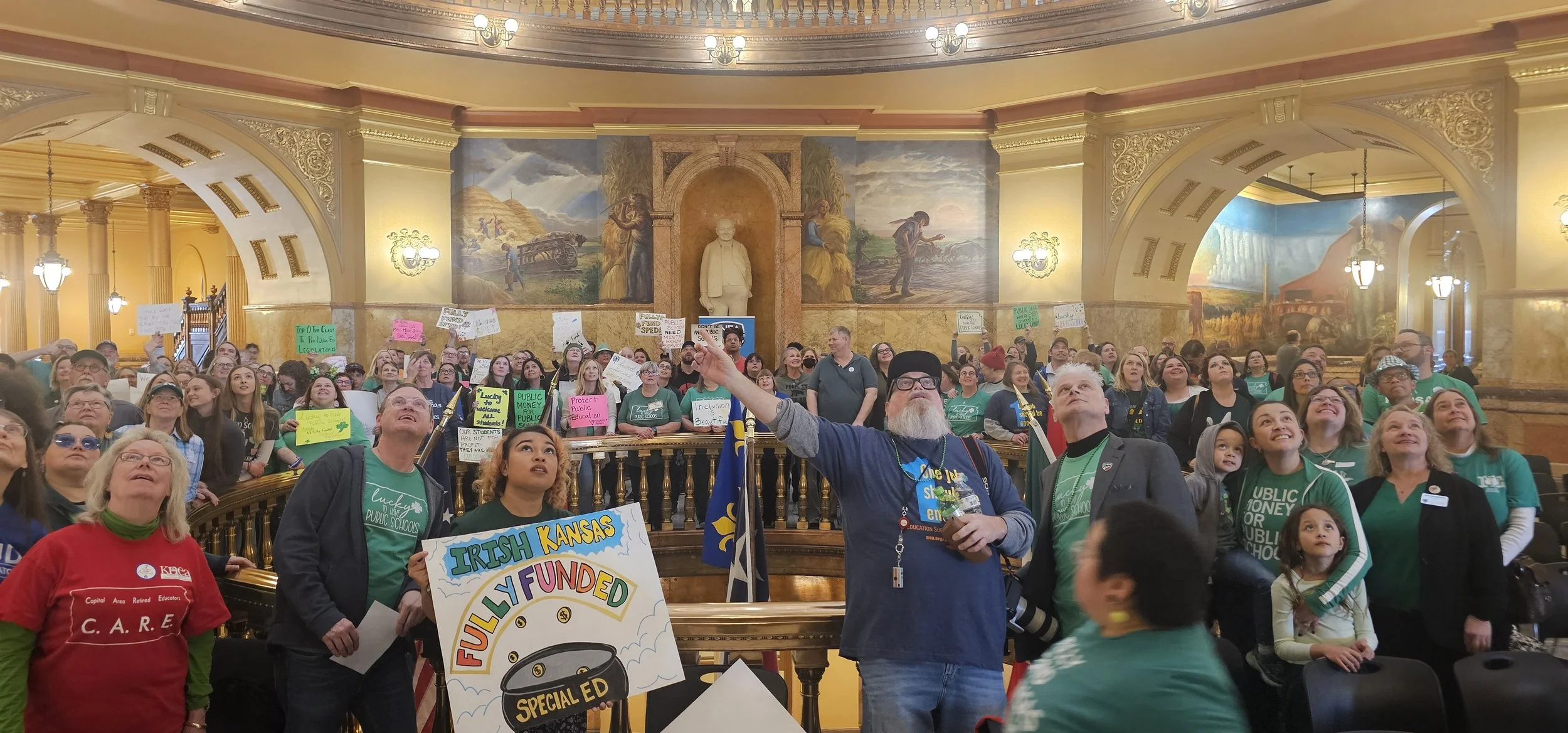   PHOTO BY ANN MARIE BUSH/KNEA    Rally participants looked up for a group photograph after the March 17 Lucky to Have Kansas Public Schools Rally.  