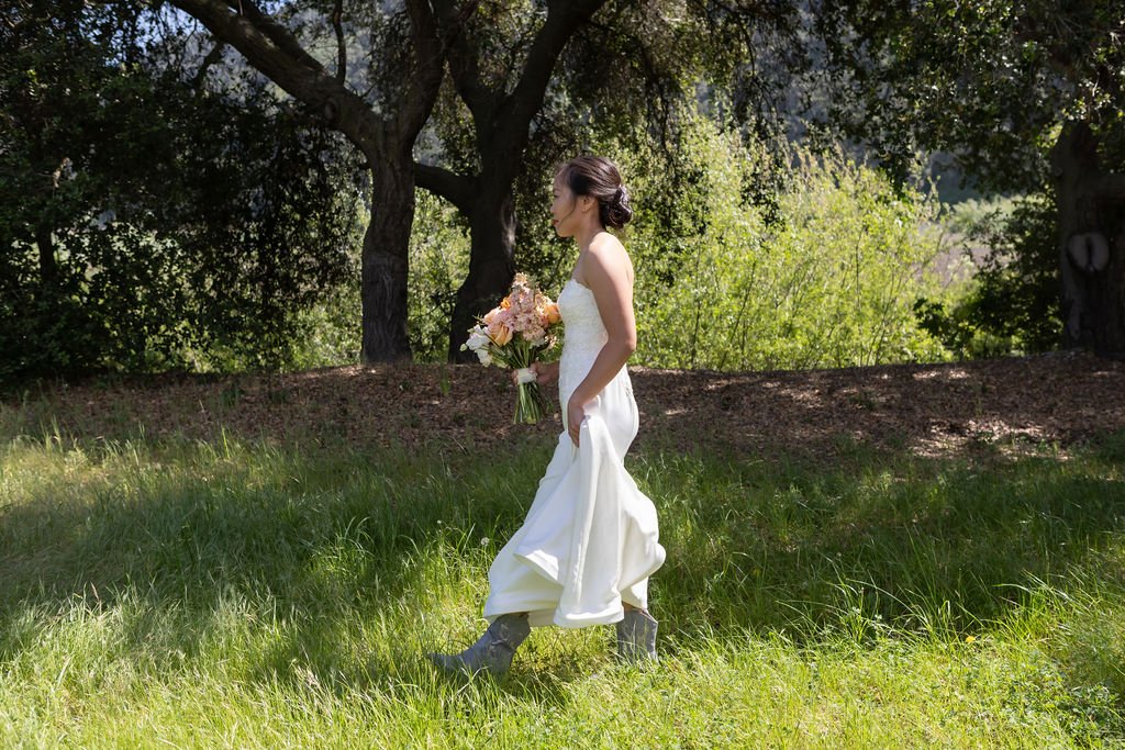 Bride walking through green spring grass at Tar Creek Ranch