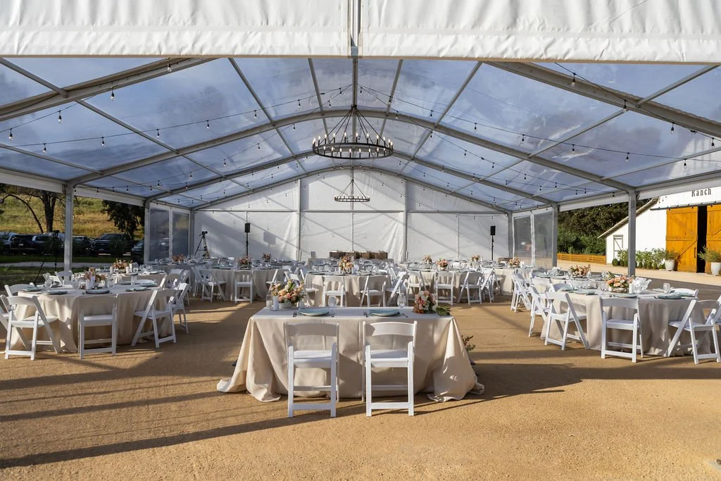 Elegant wedding dinner setup beneath the clear Magnolia Pavilion at Tar Creek Ranch