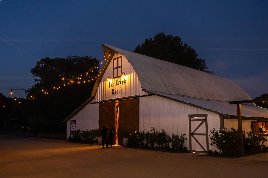 Historic Tar Creek Ranch barn illuminated at blue hour