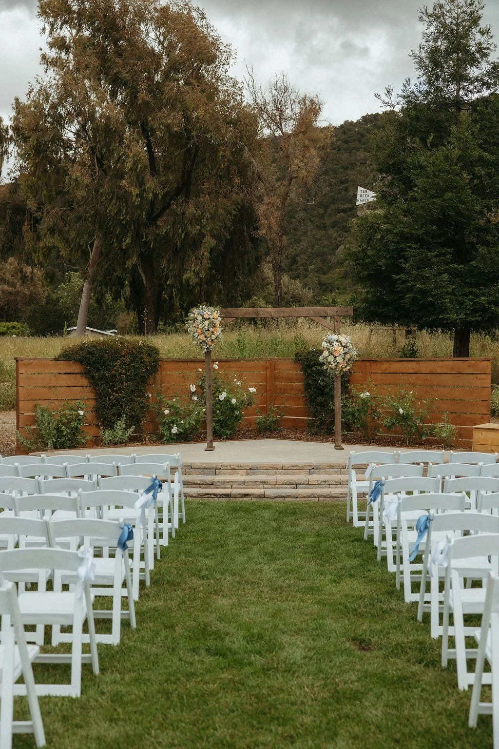 Garden ceremony aisle and wooden arch decorated with spring florals