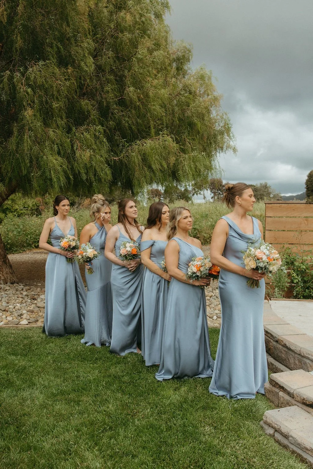 Bridesmaids in dusty blue dresses during a spring garden wedding ceremony