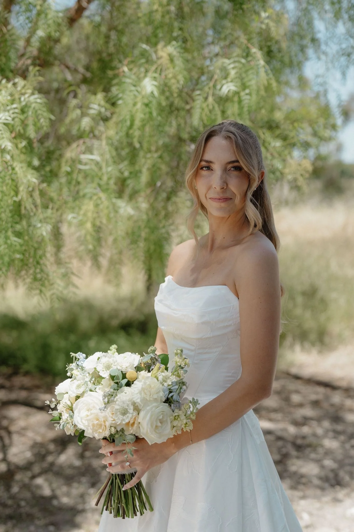 Hannah holding a cream yellow and pale blue spring bridal bouquet