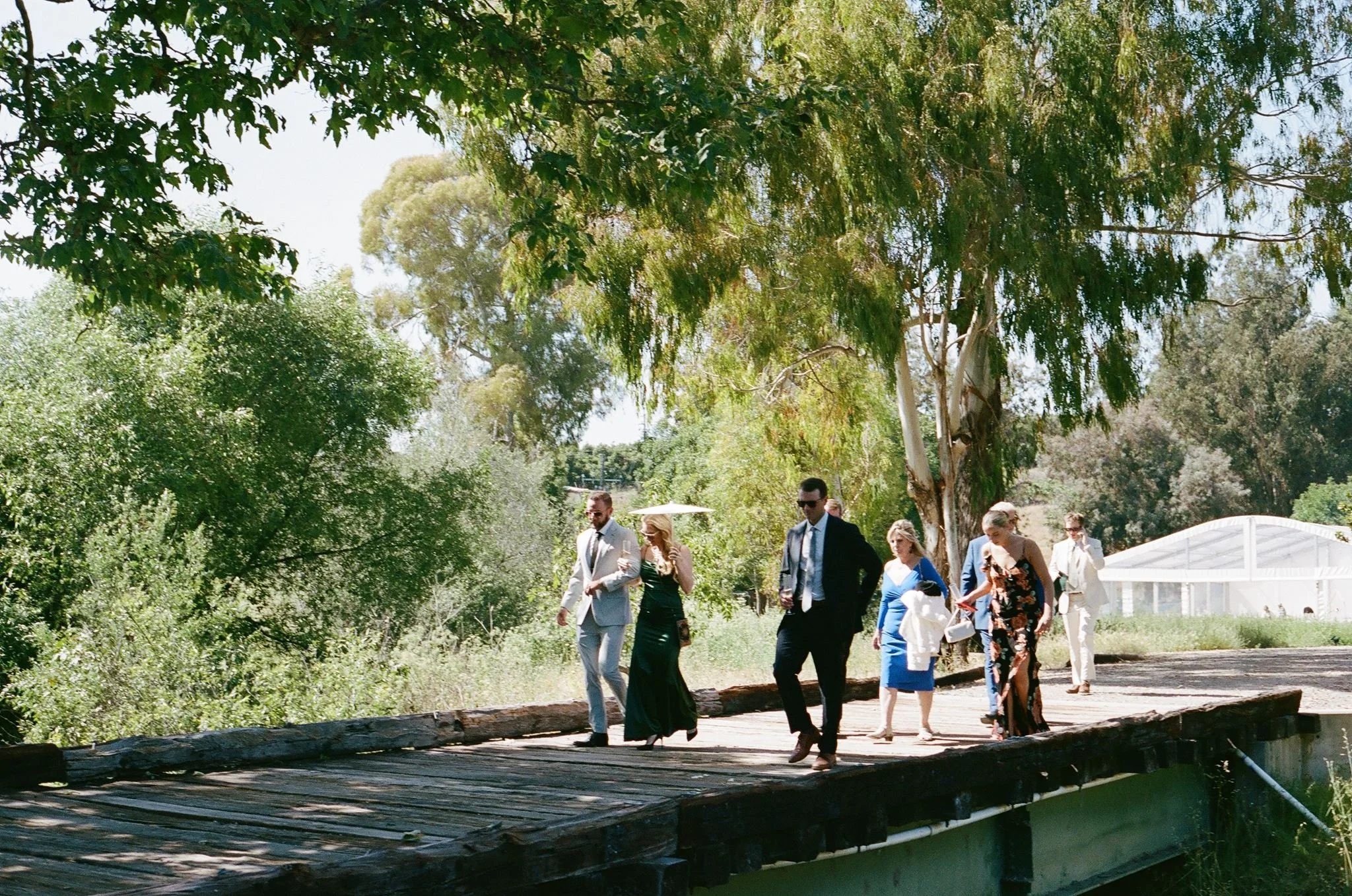 Wedding guests crossing the bridge to a Meadow ceremony at Tar Creek Ranch