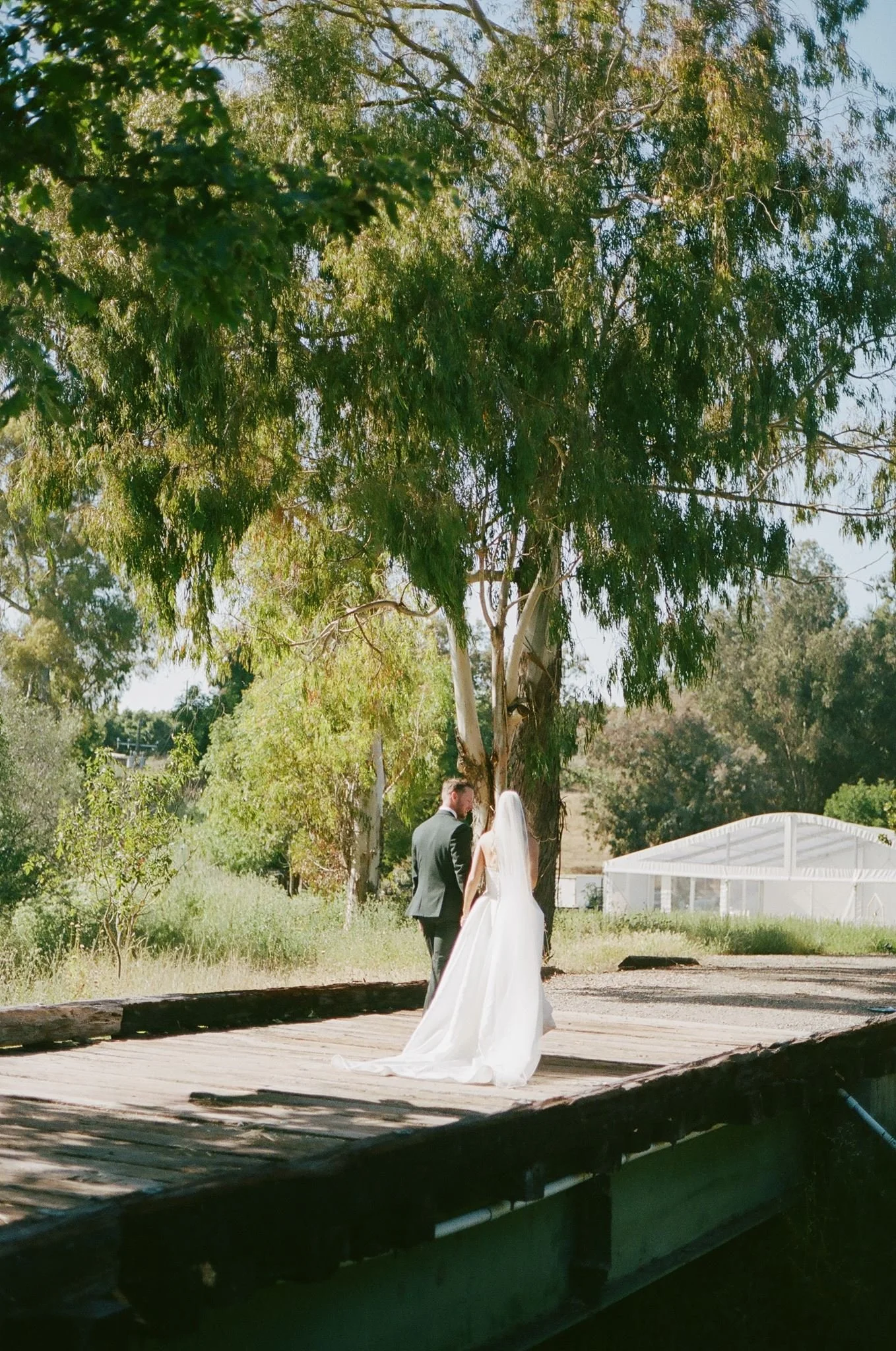 Newlyweds crossing the rustic bridge after their Tar Creek Ranch ceremony