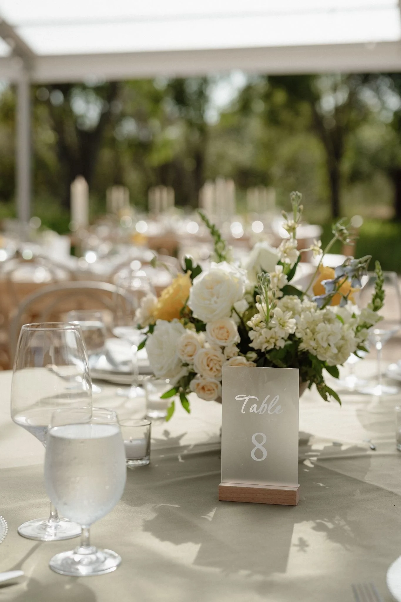 Cream yellow and pale blue spring wedding centerpiece at table eight