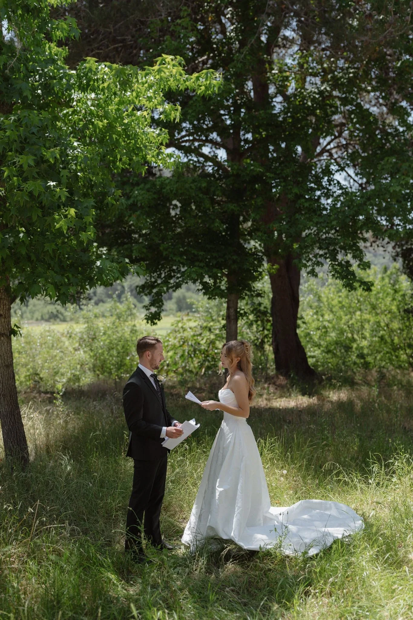 Hannah and Connor reading private vows beneath the trees at Tar Creek Ranch