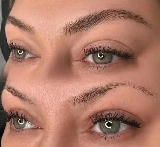 Close-up of a woman's face showing her eyebrows, eyelids, and green eyes with makeup, with an emphasis on her eyebrows.